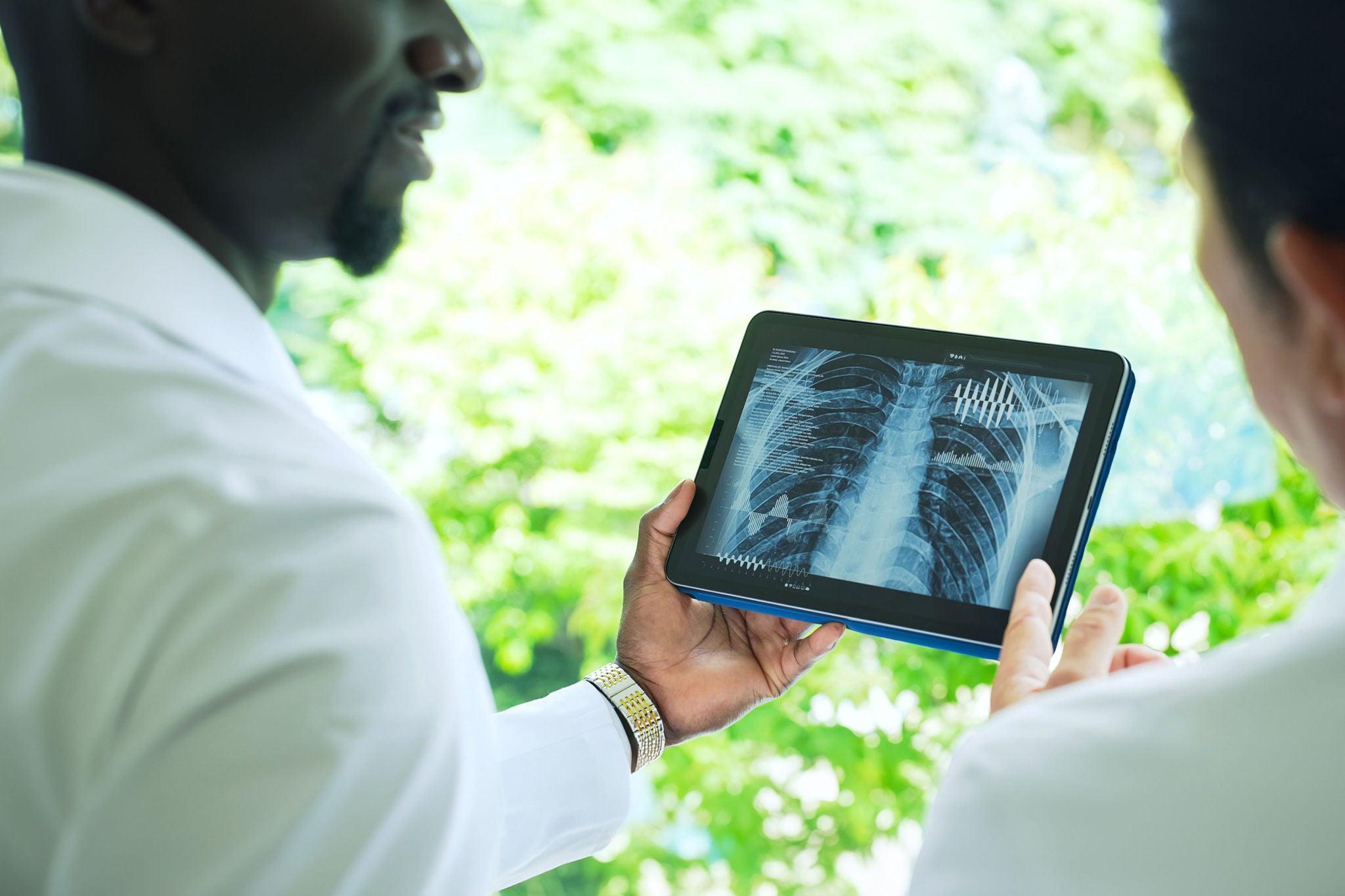 A group of researchers looking at medical data on a tablet