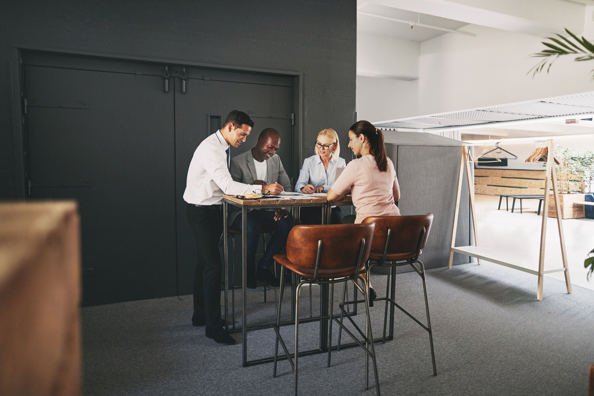 Smiling group of diverse businesspeople working together around a table in a modern open planned office