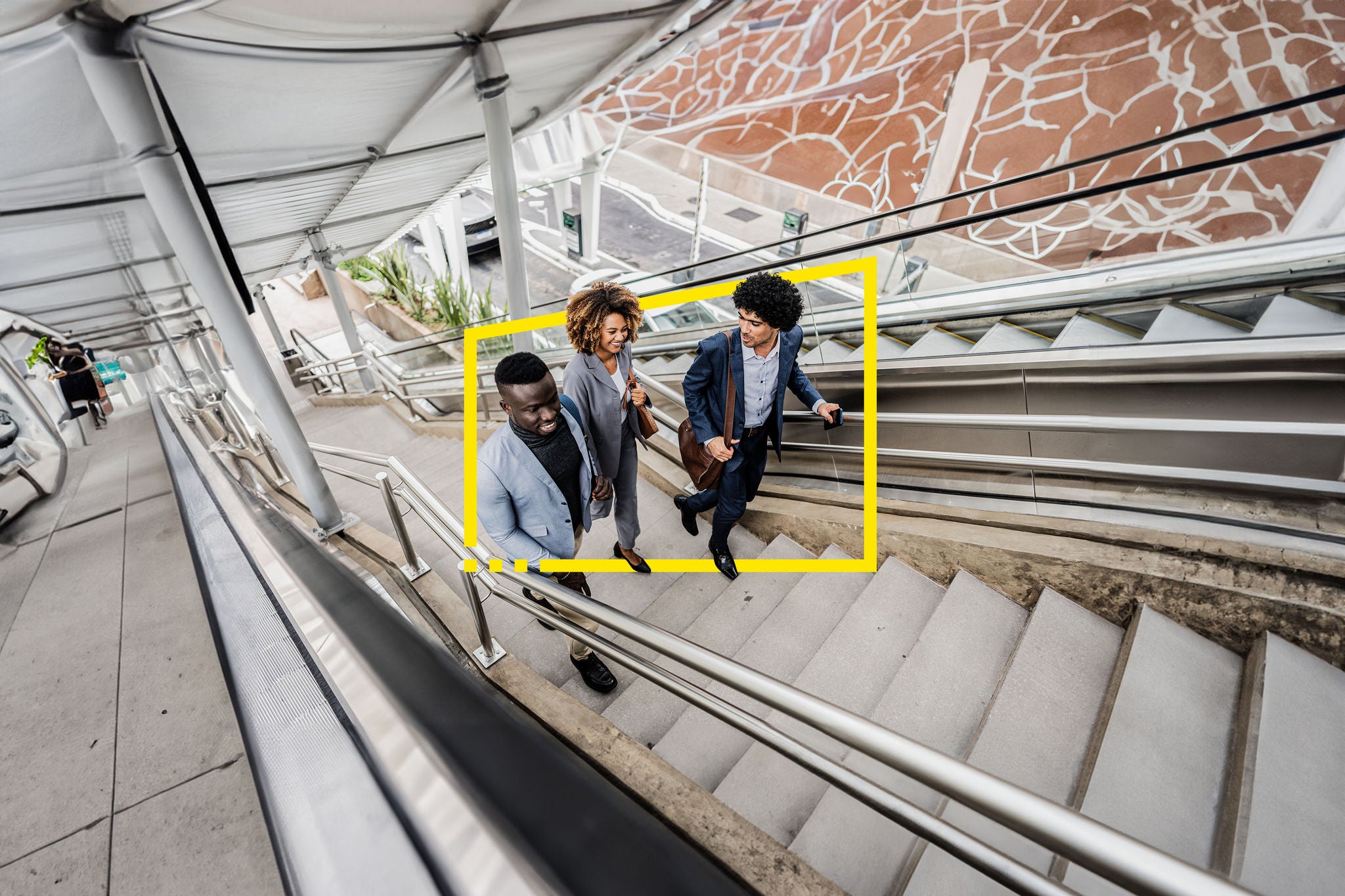 Three persons on the escalator