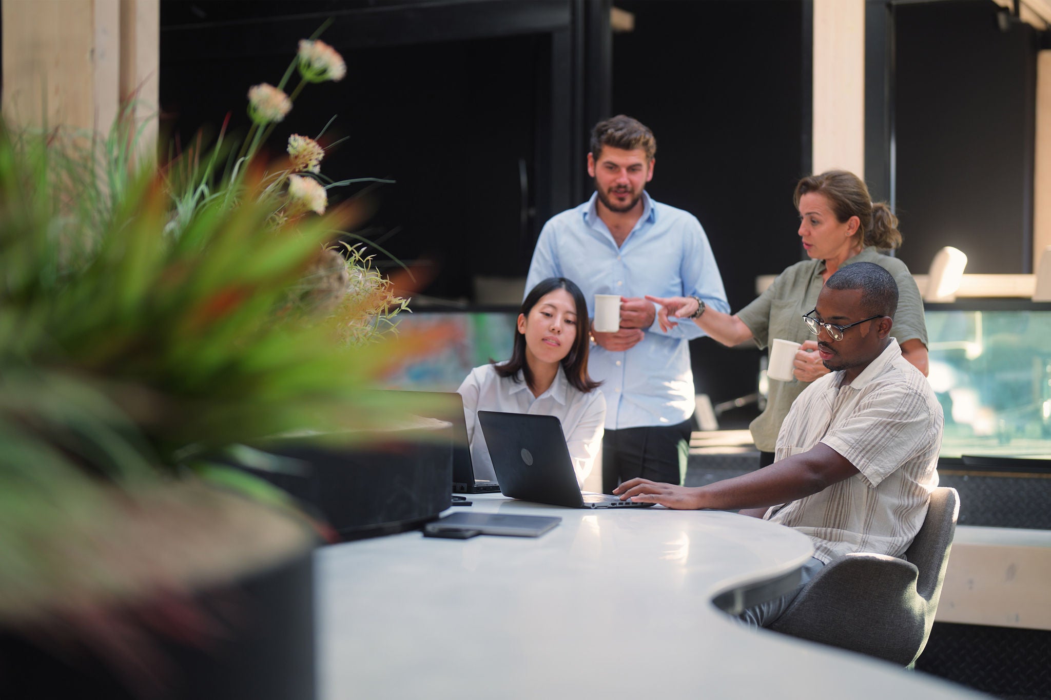 Professionals having business discussion with laptop and coffee