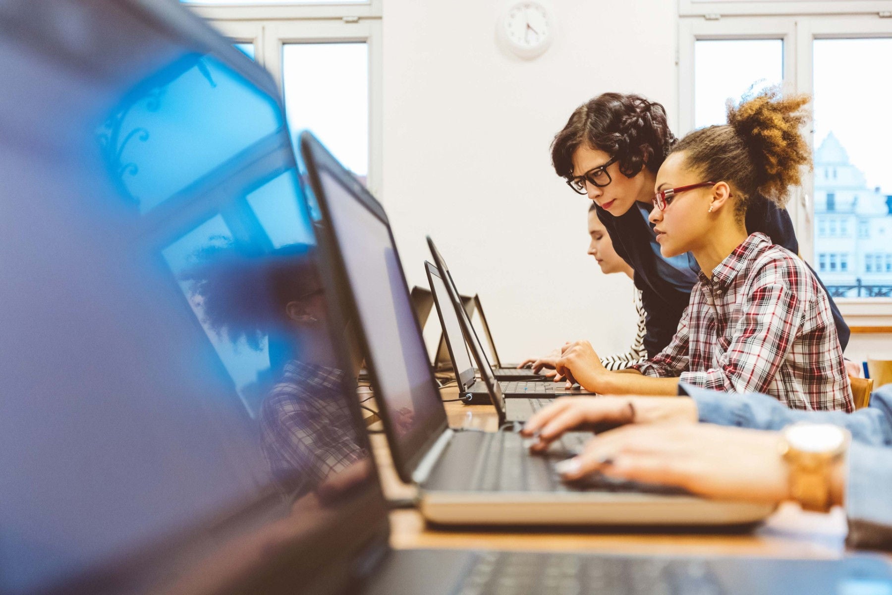 Multiethnic group of women learning computer programming