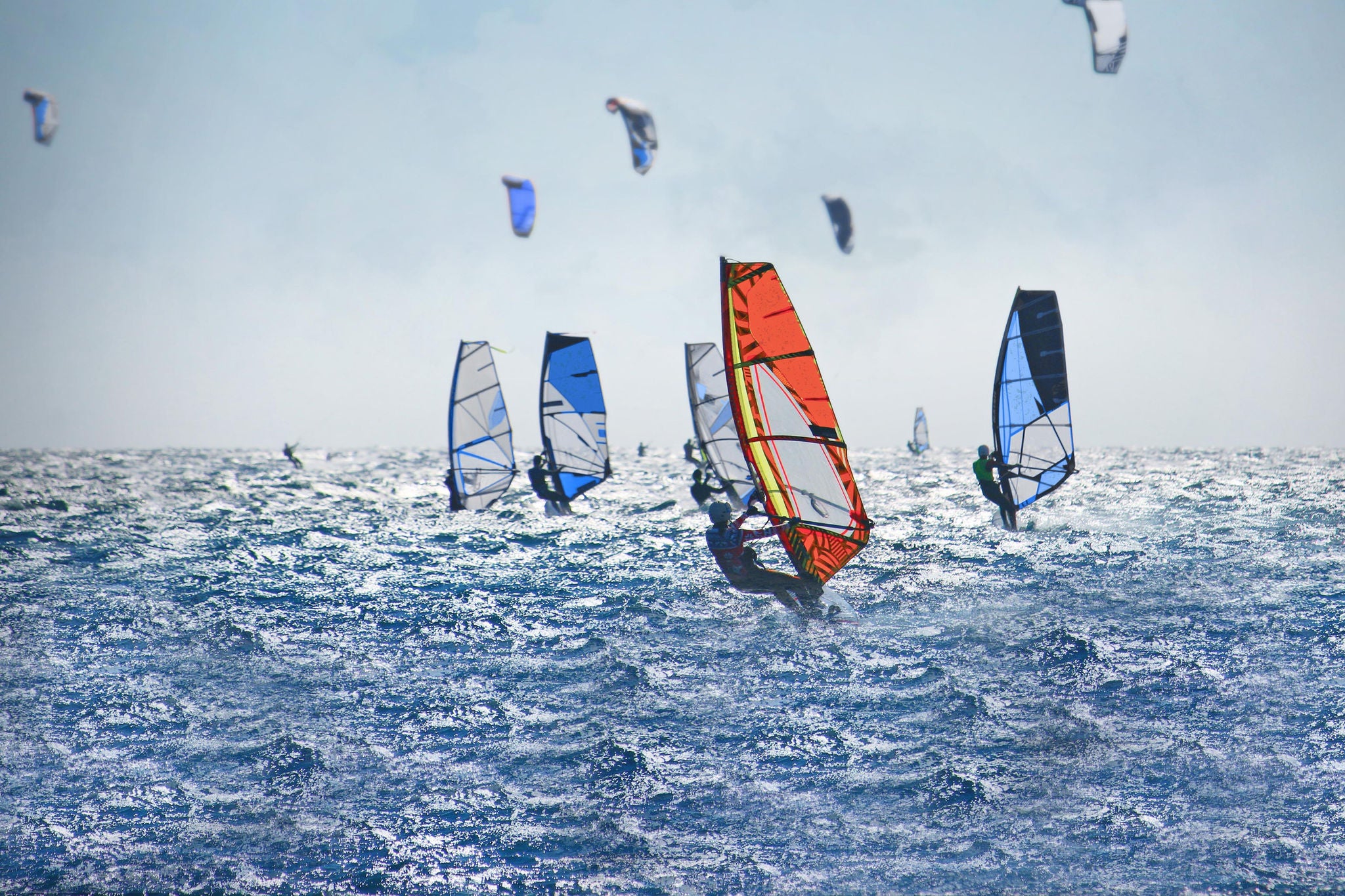 Windsurfers and kiteboarders on choppy sea