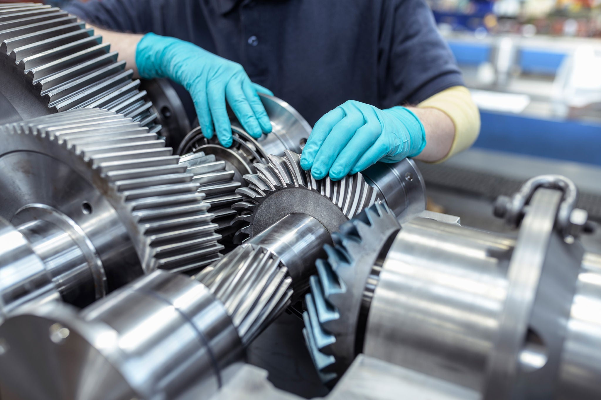 A man wearing blue glove is inspecting machines