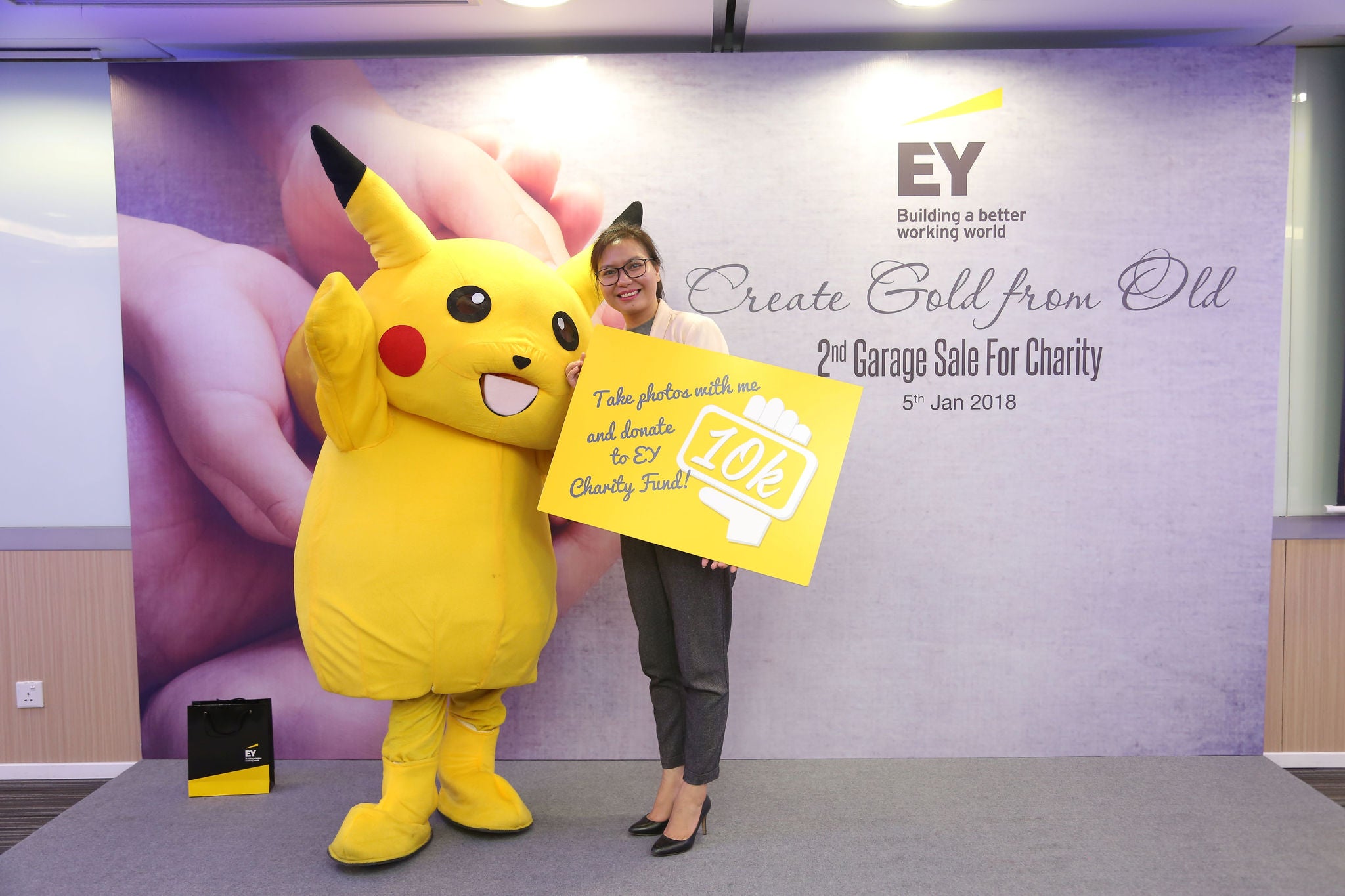 A lady posed for a photograph beside pikachu toy