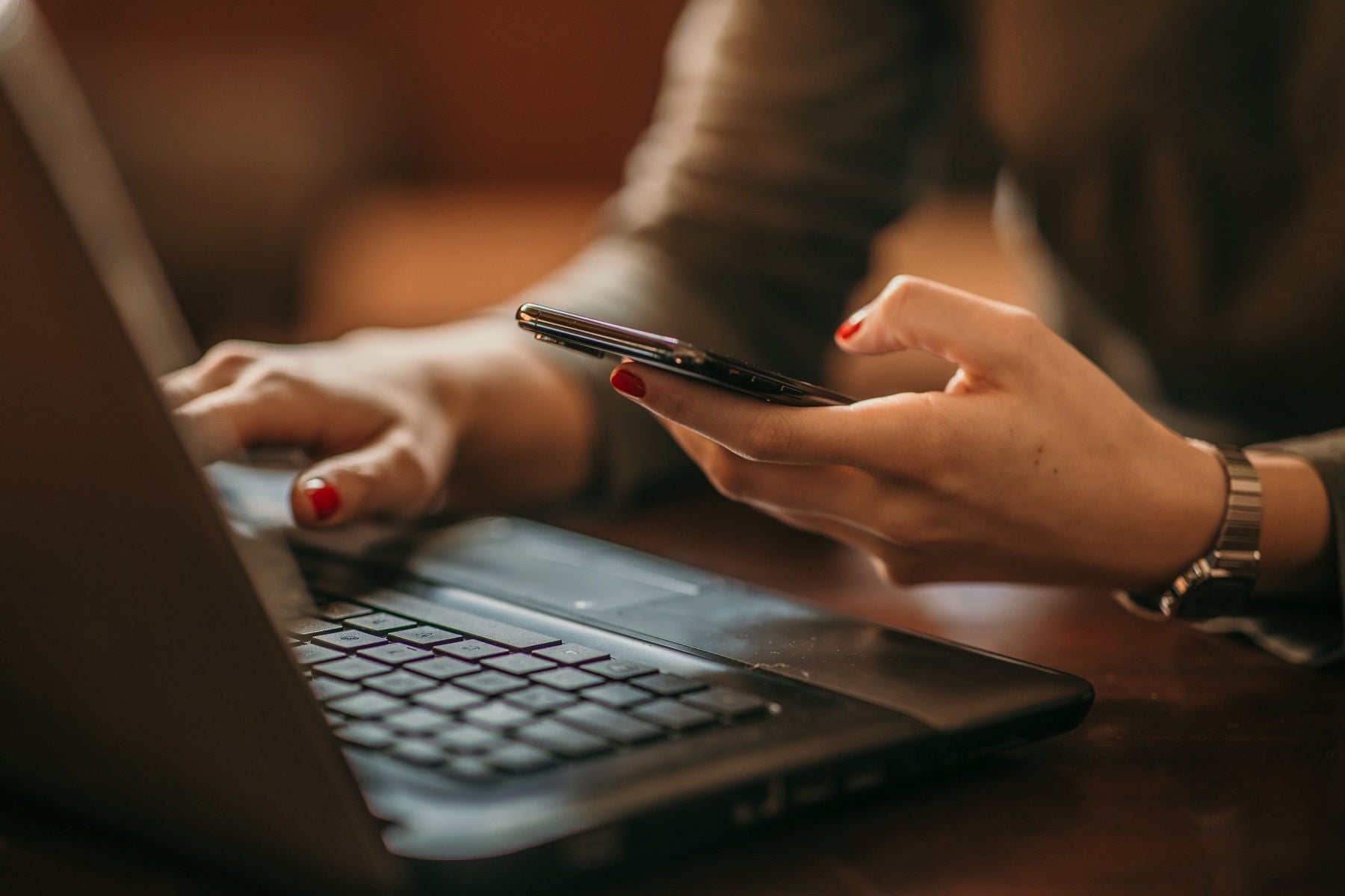 A person is using both mobile and laptop