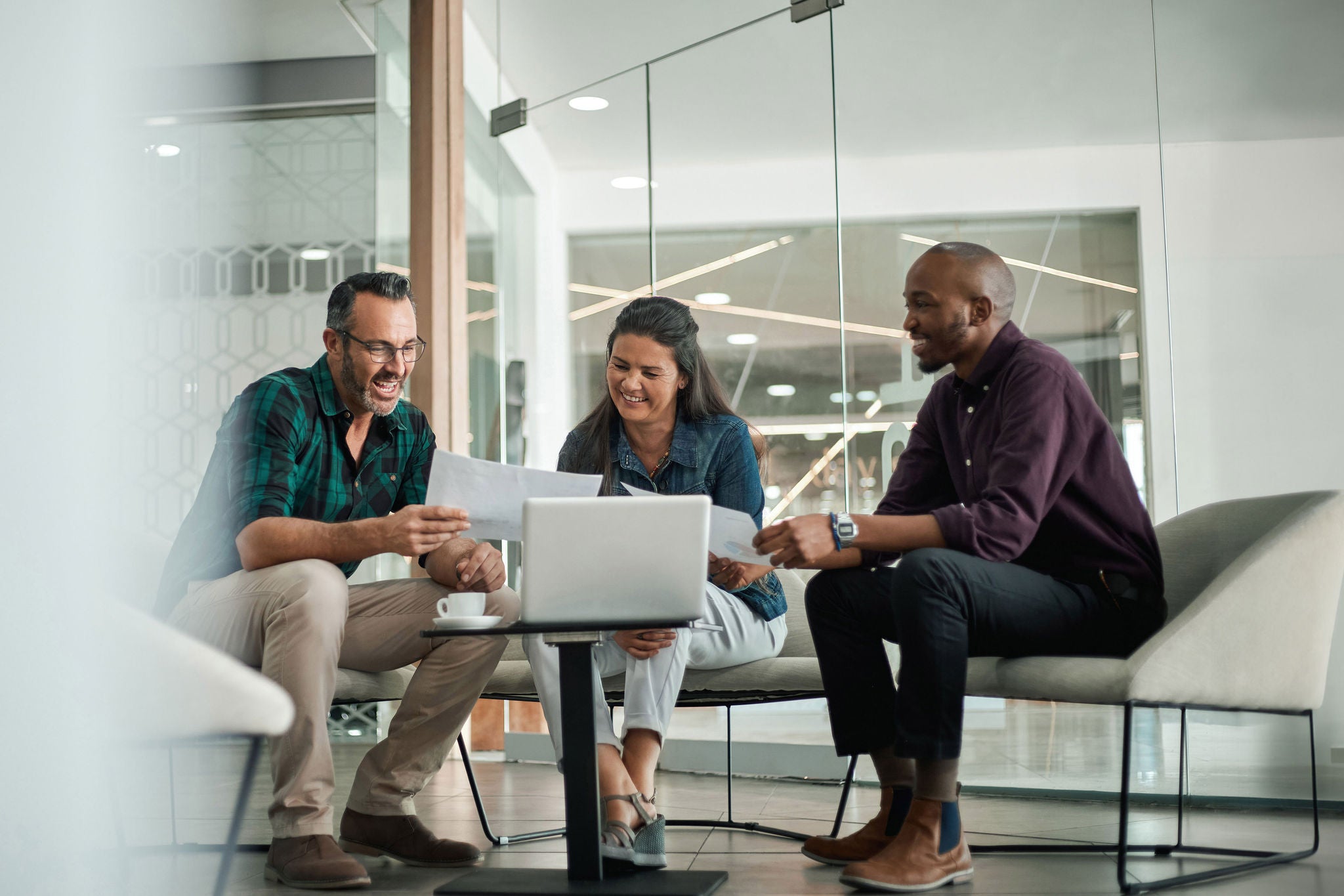 Casual meeting of smiling diverse business team analyzing financial data