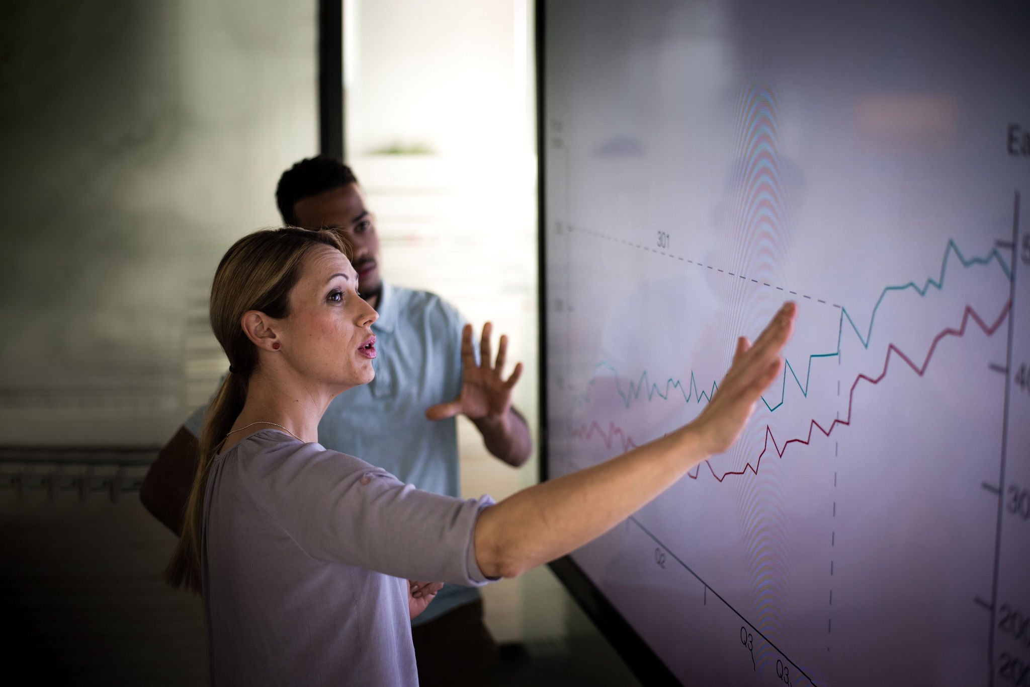 Businesswoman explaining graph to his coworker in conference room