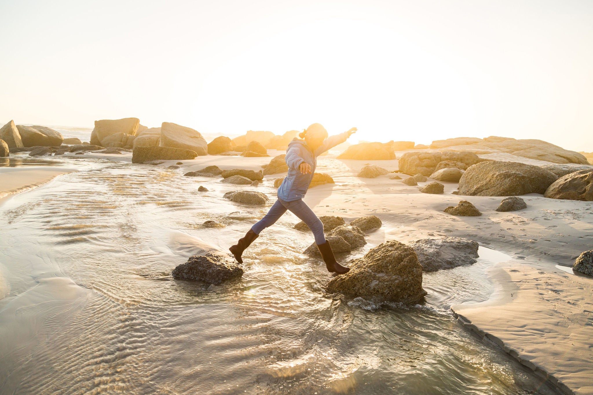 Woman jumping on top of rocks