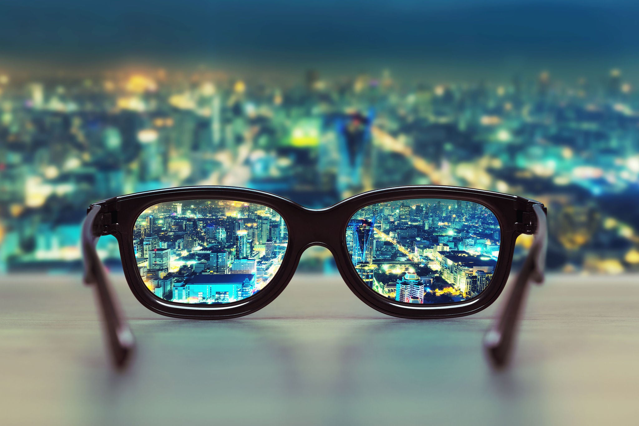 Glasses resting on table overlooking city