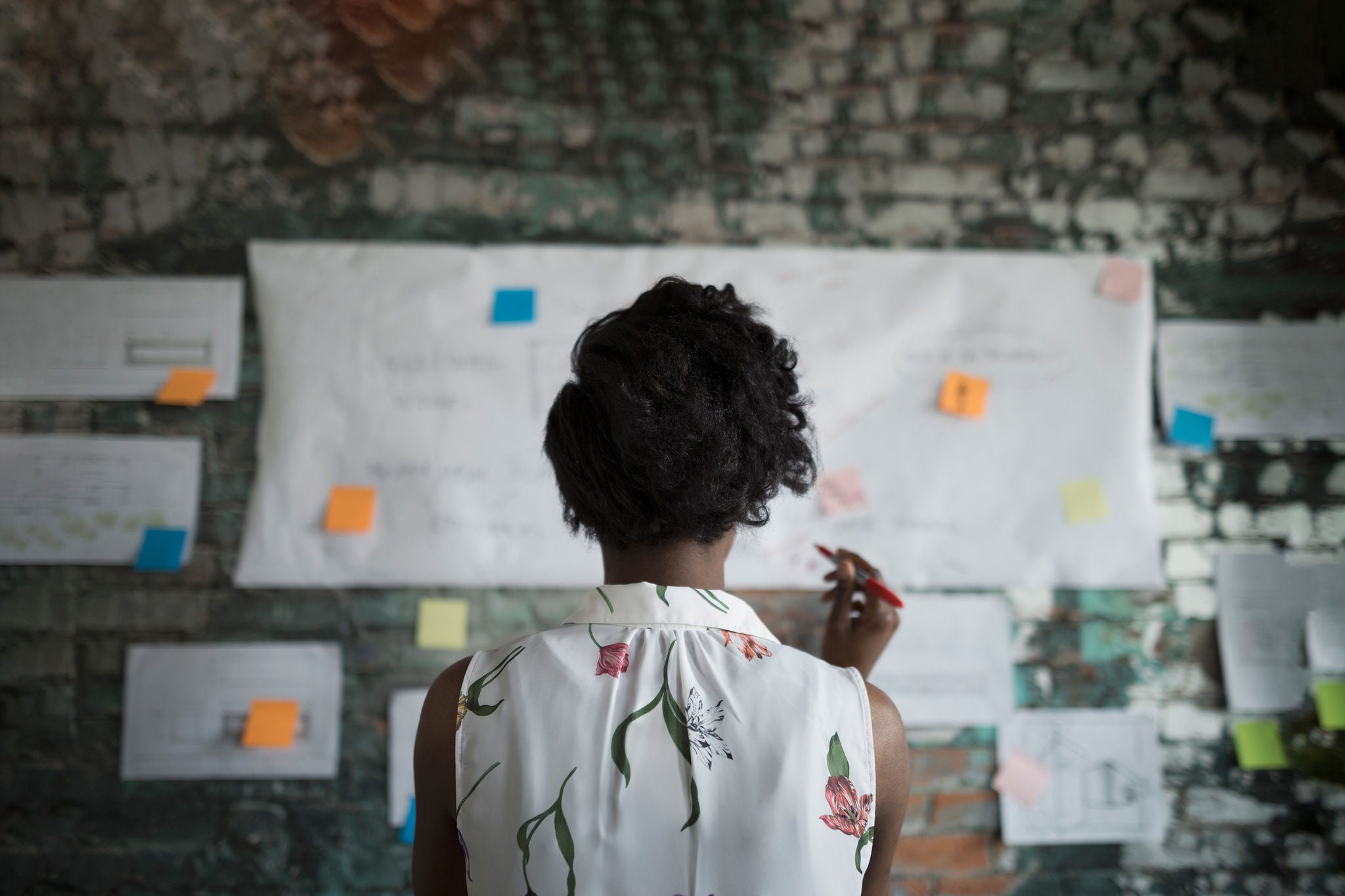 businesswoman brainstorming flow chart hanging on wall hero