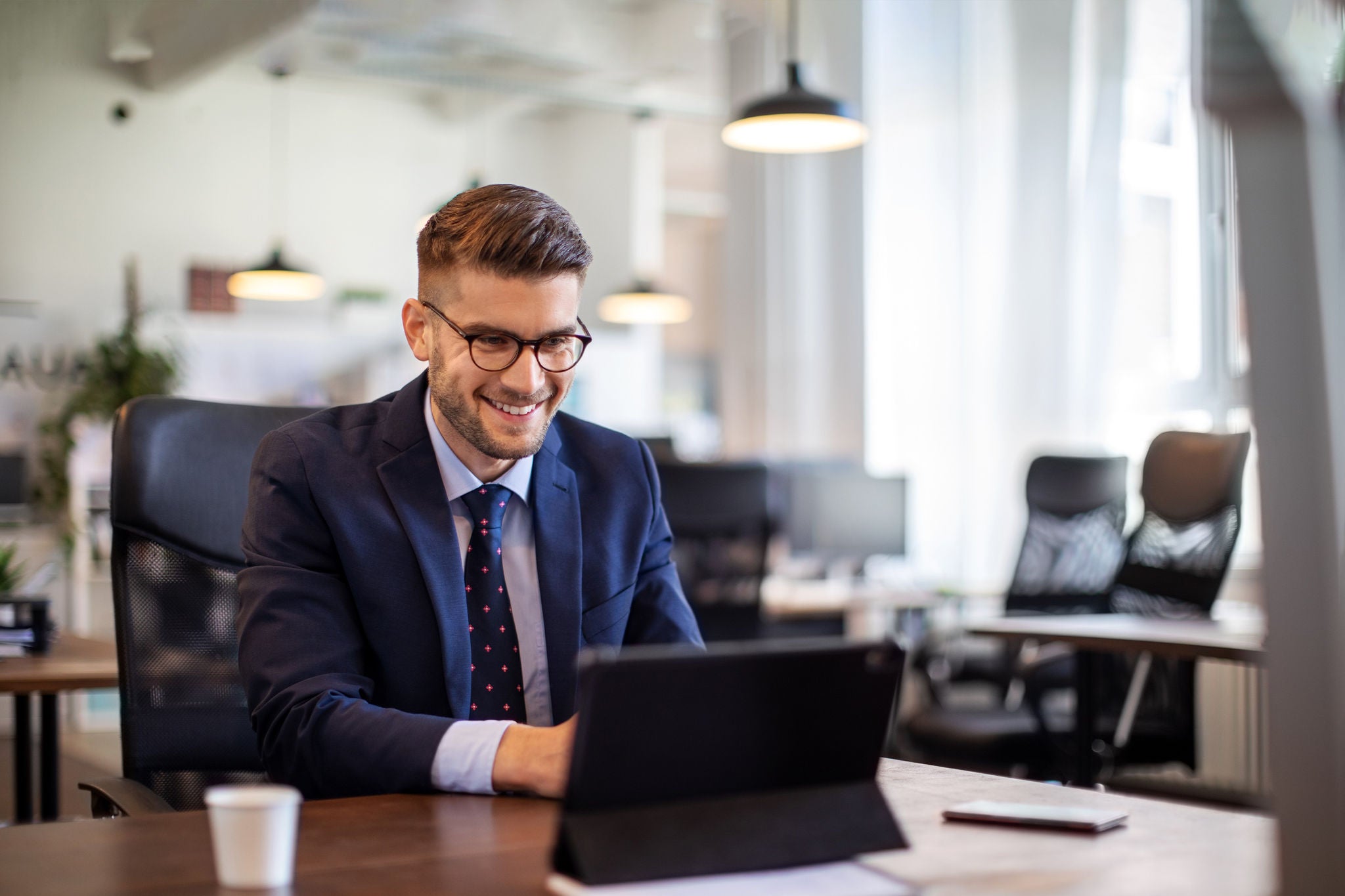 man with glasses working on tablet