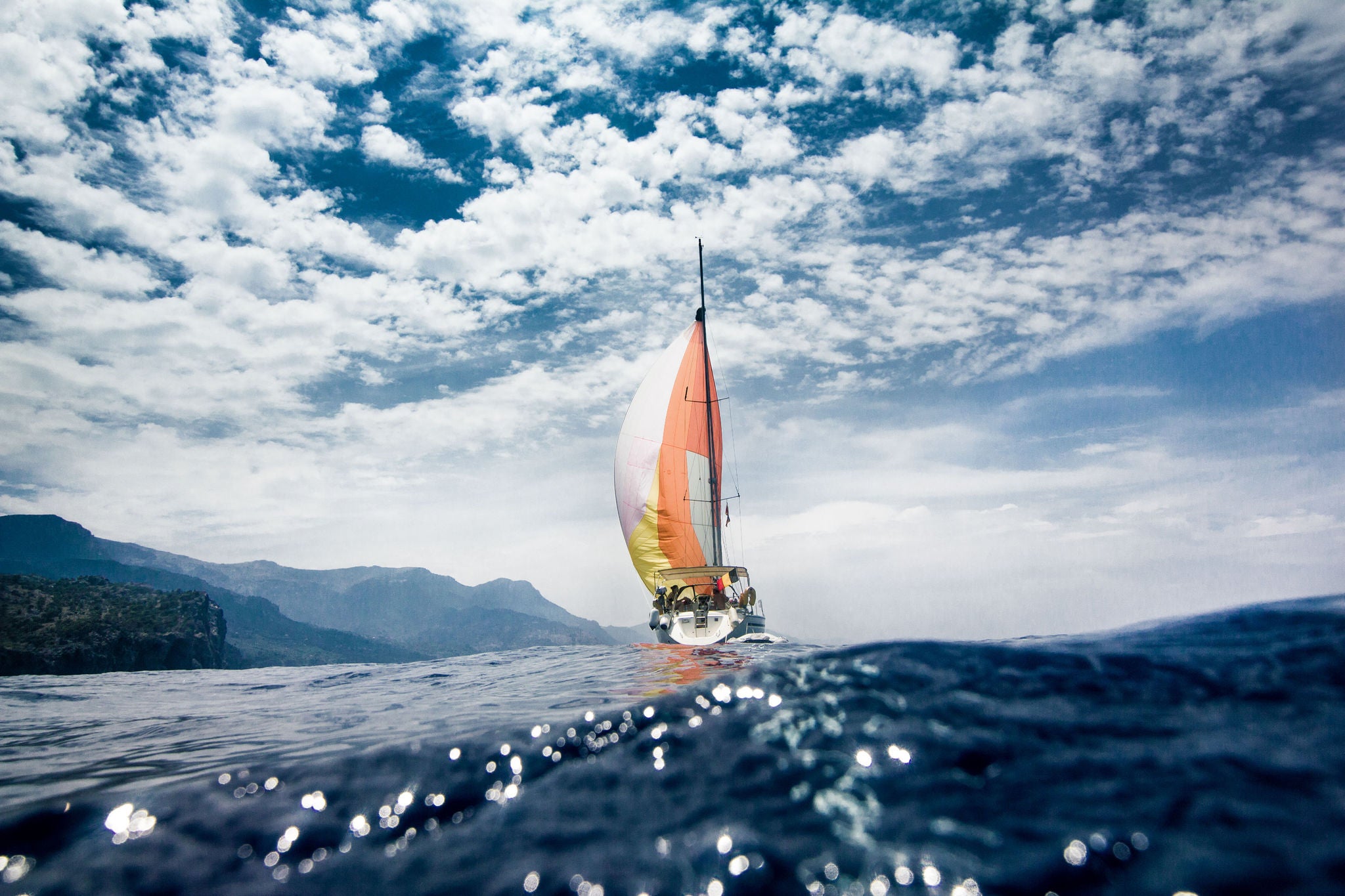 Low angle boat sailing sea cloudy sky islands