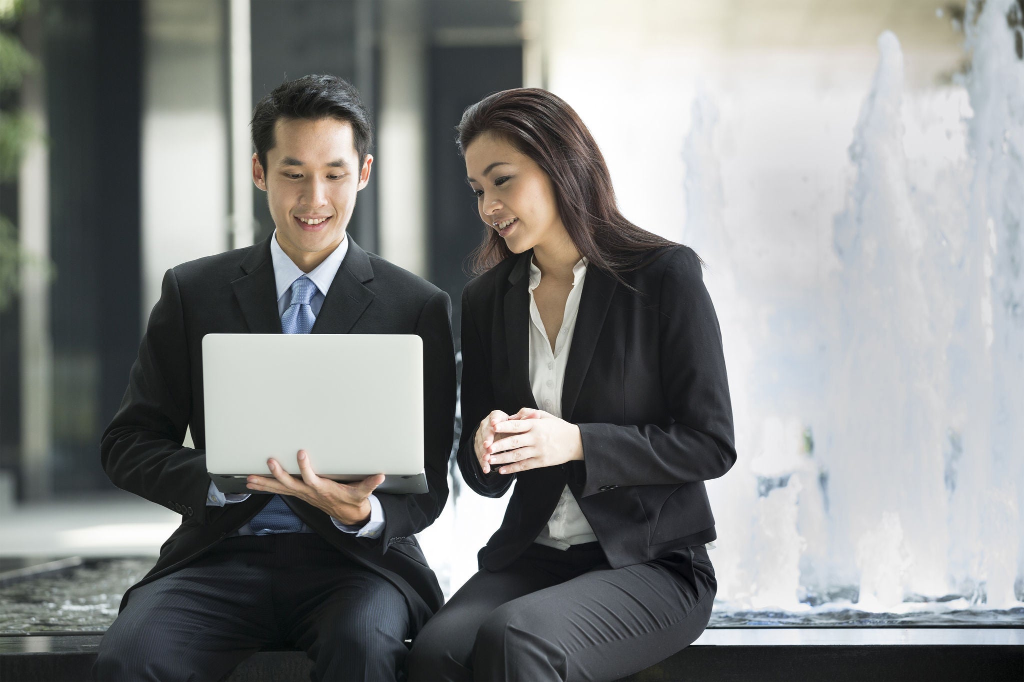 Asian business people working together on a laptop