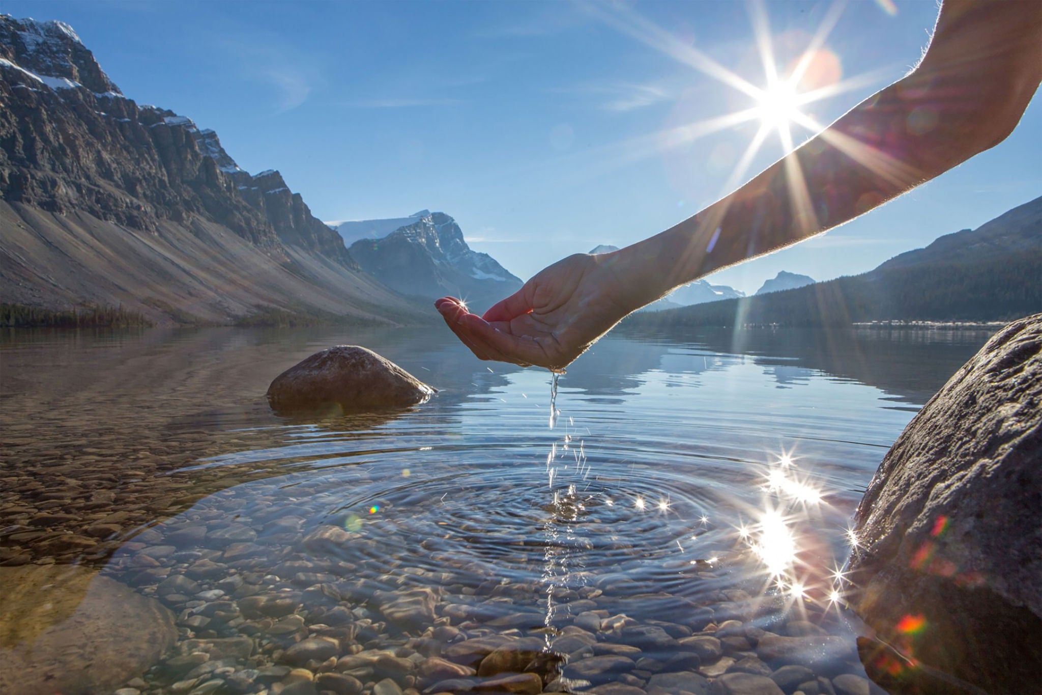 Mão humana em concha para pegar a água fresca do fundo do lago