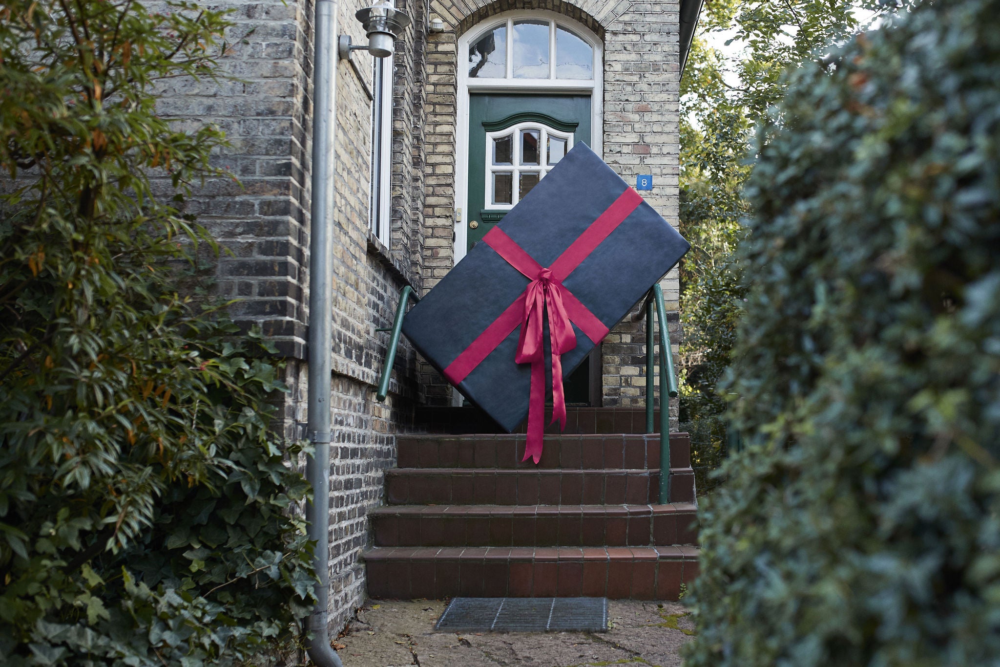 Large gift box on steps at entrance of house 