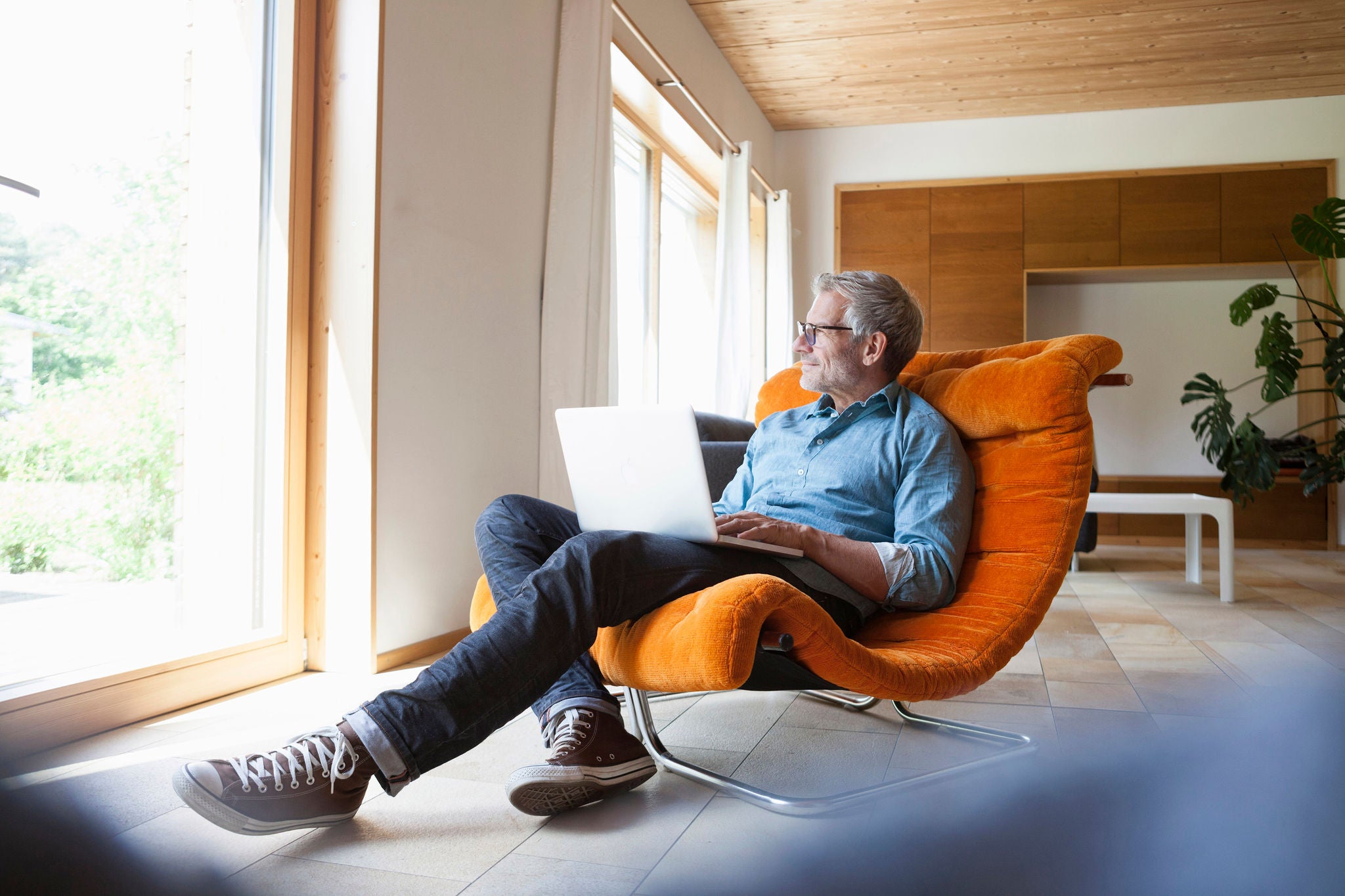 Man sits in armchair and looks out the window