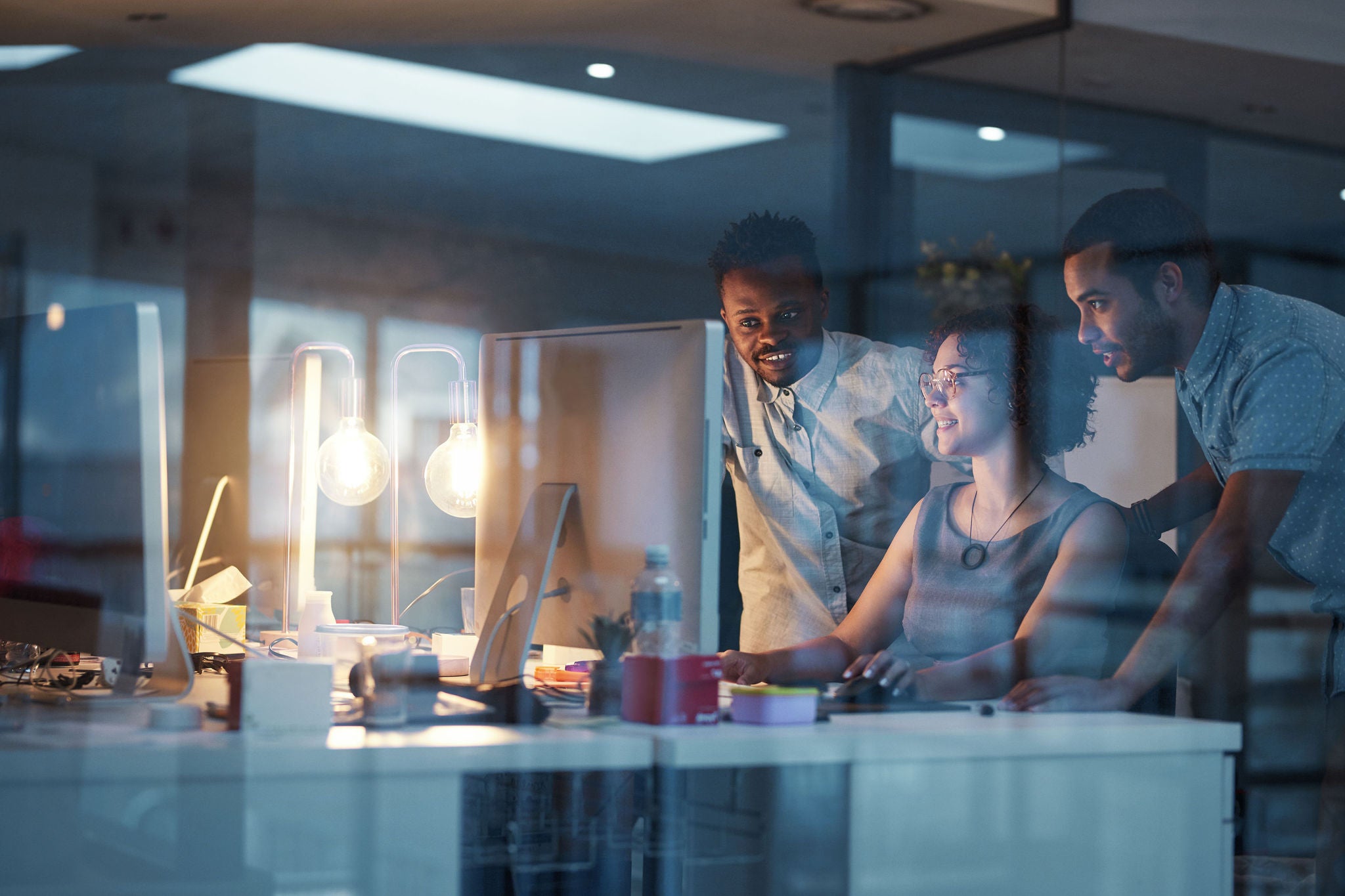 Cropped shot of young colleagues working in a modern office at night