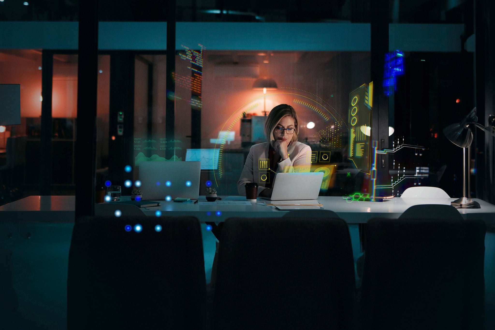 Businesswoman using a laptop at her desk during a late night at work