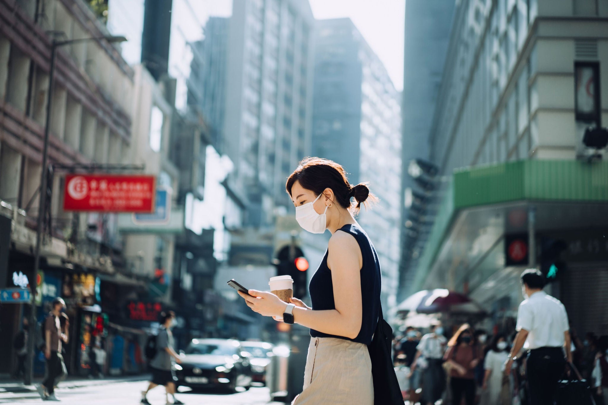 Young Asian woman with mask holding a cup of coffee