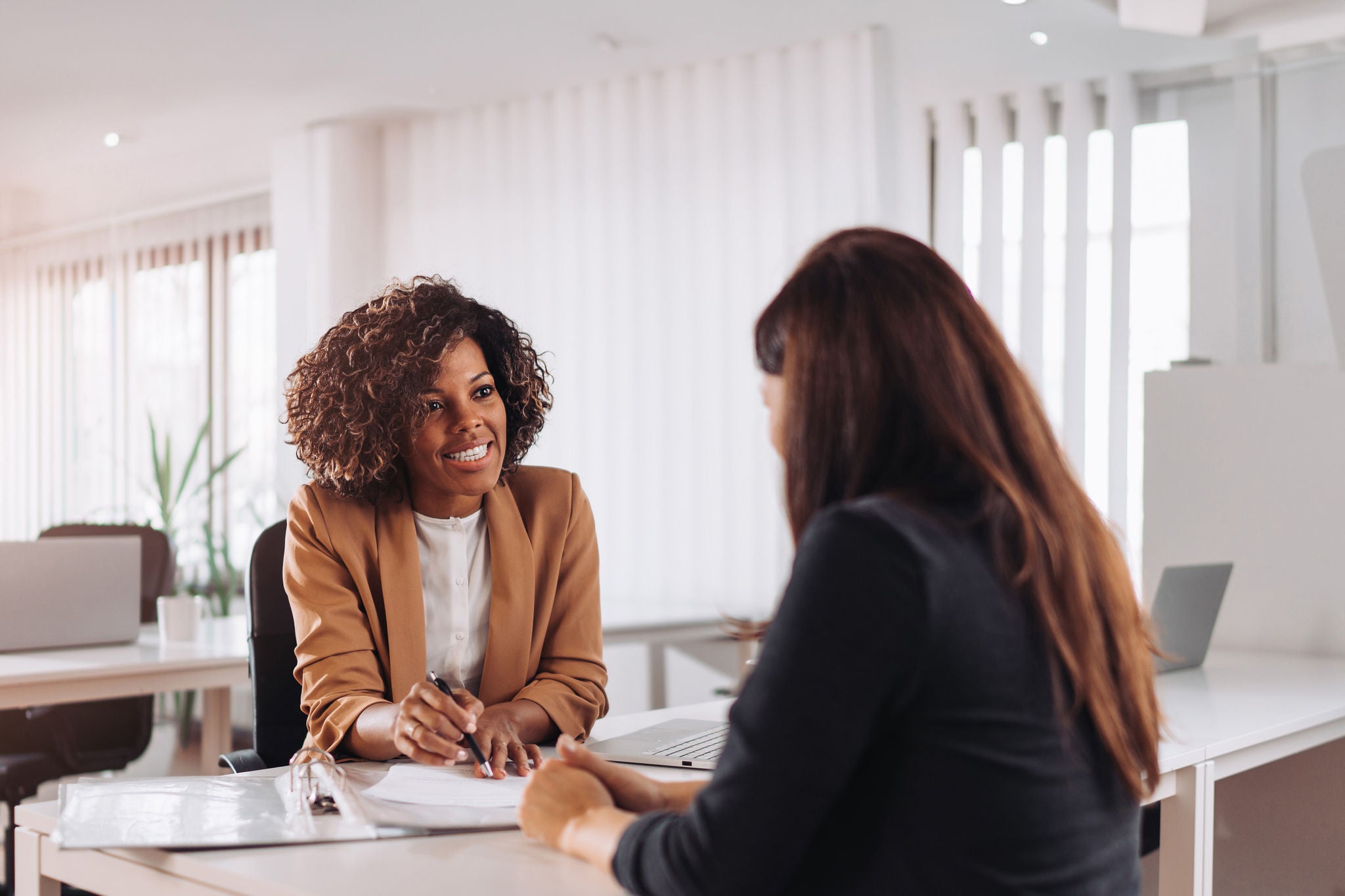 Female financial consultant manager talking with a client at the bank