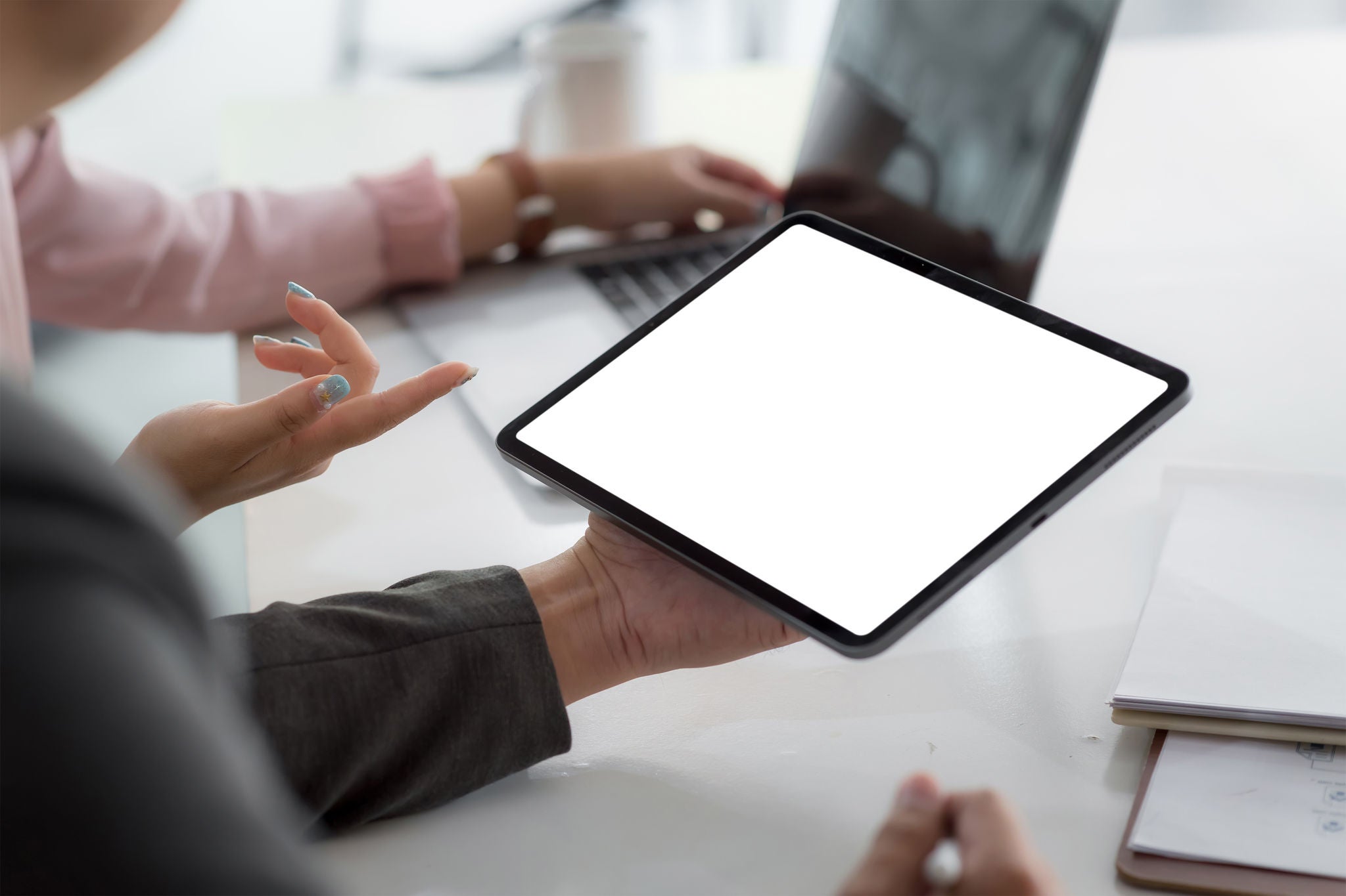 Close up business people holding a tablet blank white screen in the meeting room. Mock up.