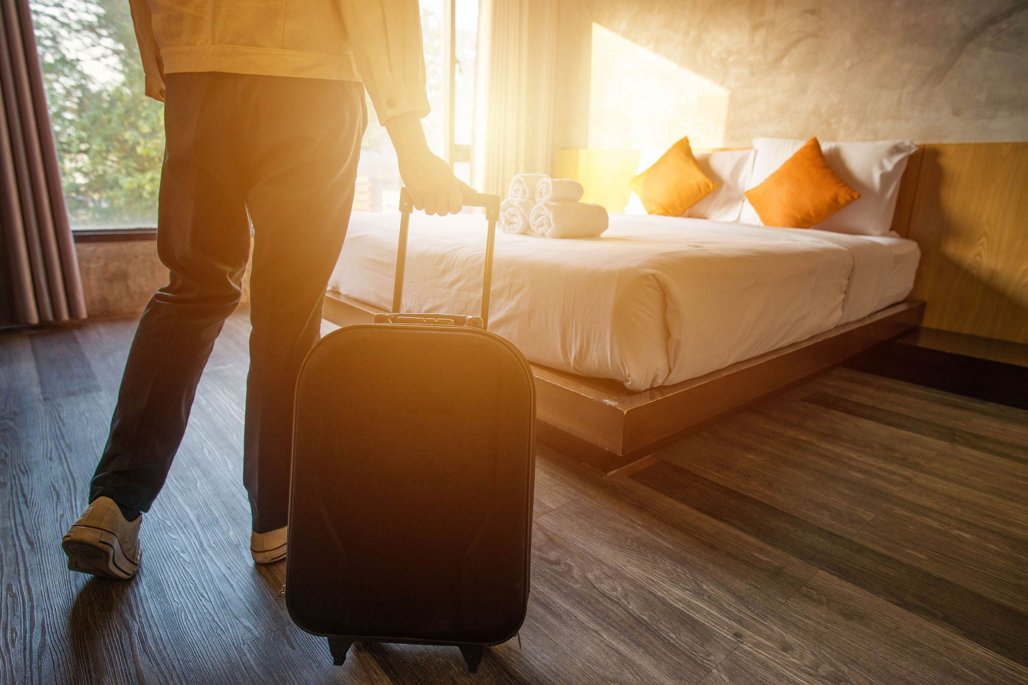 Cropped shot of tourist woman pulling her luggage to her hotel bedroom after check-in. Conceptual of travel and vacation., Cropped shot of tourist woman pulling her luggage to her hotel b