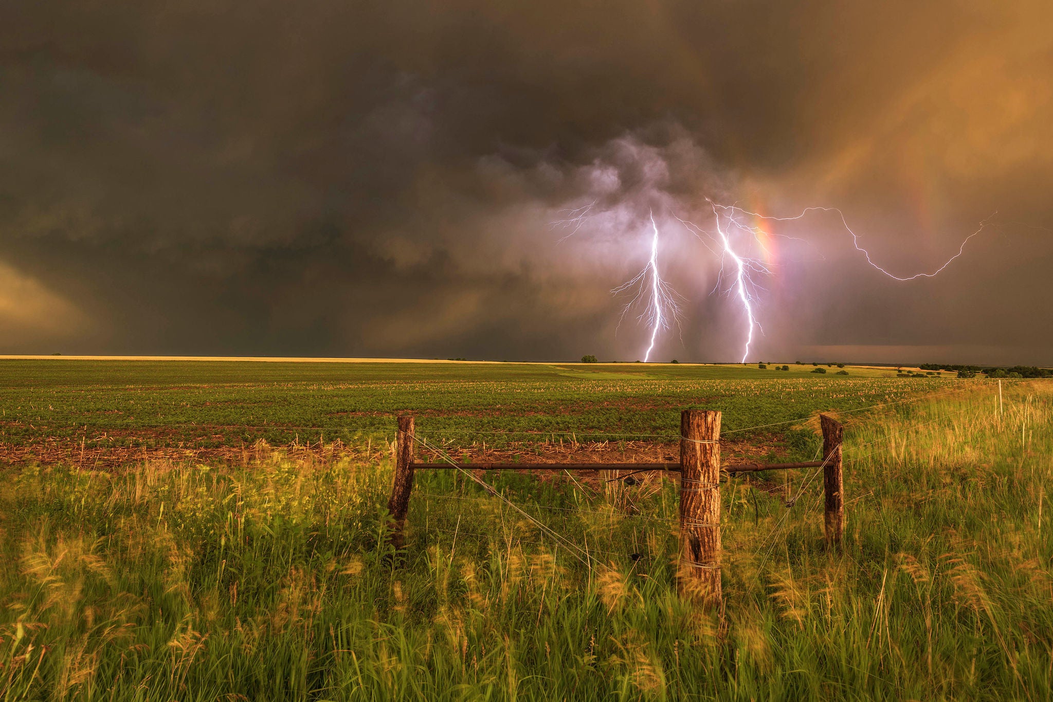 Severe thunderstorm sunset with a double rainbow and lightning on the high plains of Nebraska. USA