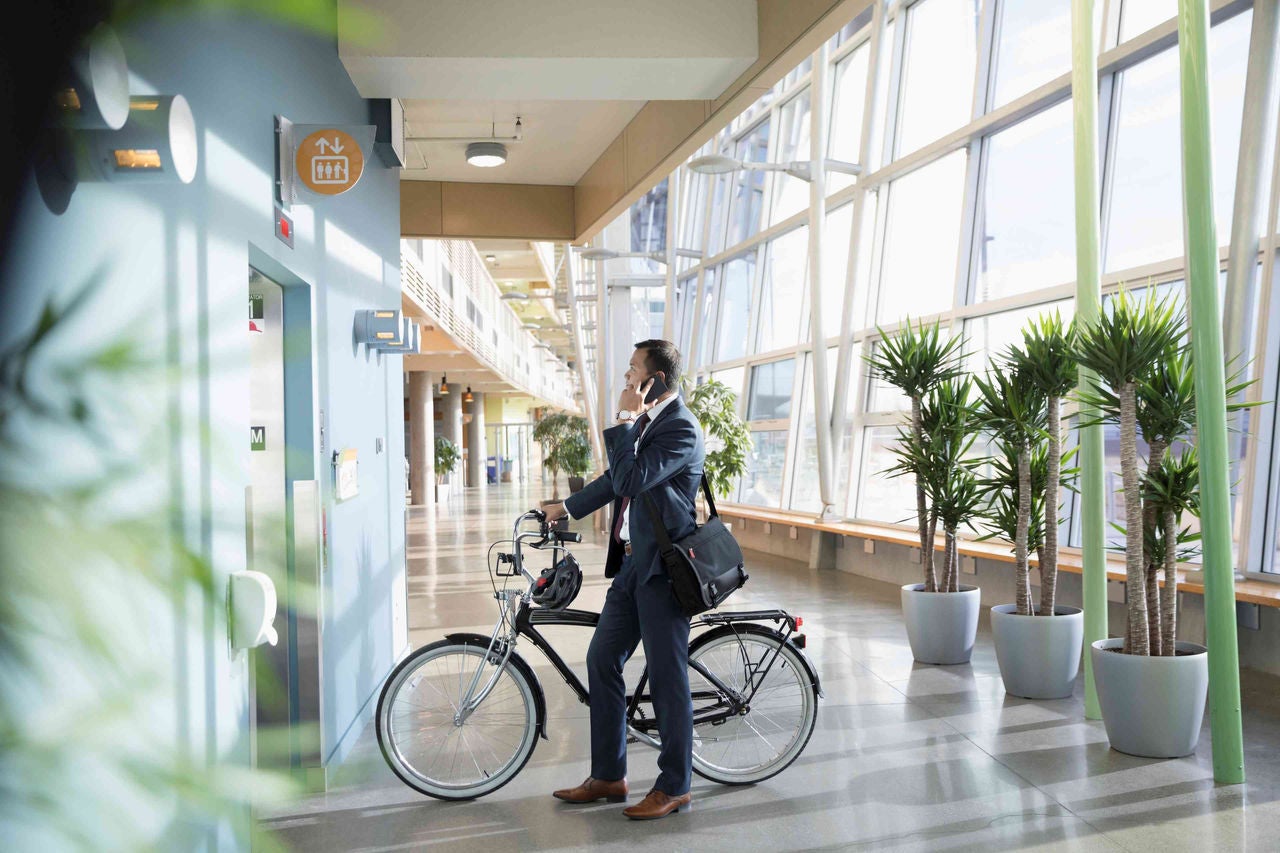 man-holding-his-bike-while-on-the-phone