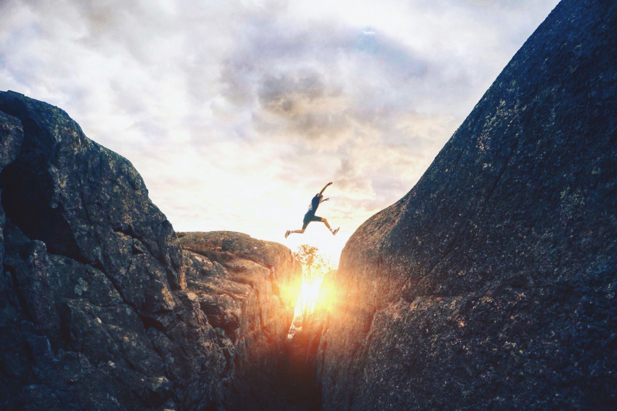 A man jumping over a ravine.