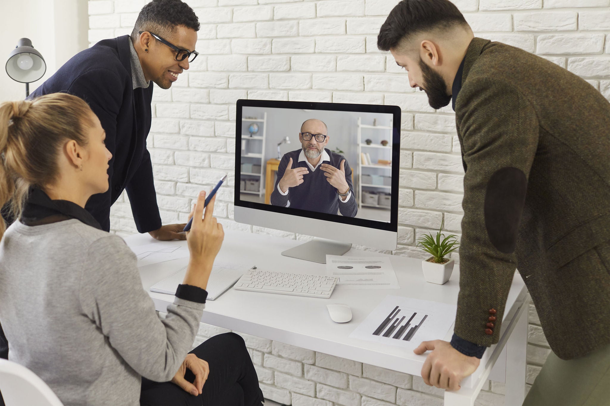 Grupp av unga företagare videosamtalar senior kollega, mentor eller chef