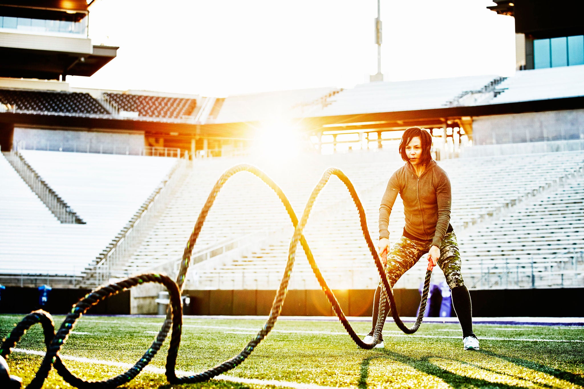 ey athlete working out battle rope stadium