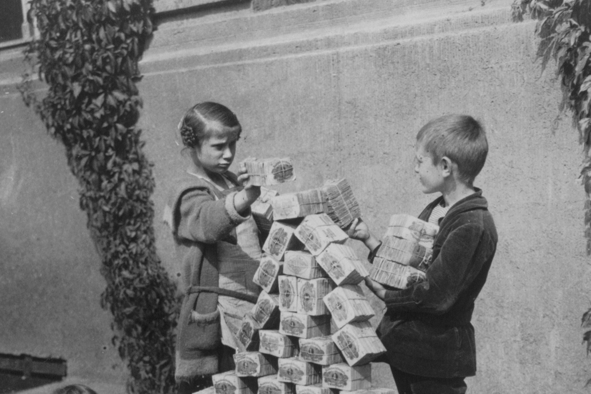 Kinder spielen 1923 mit den wertlos gewordenen Geldscheinen