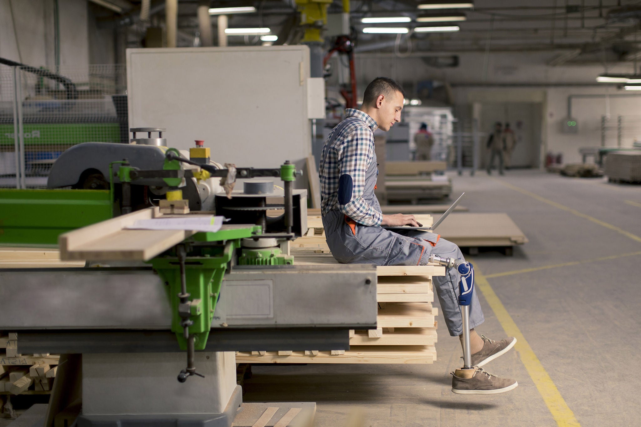 young man with an artificial leg is working at the furniture  factory