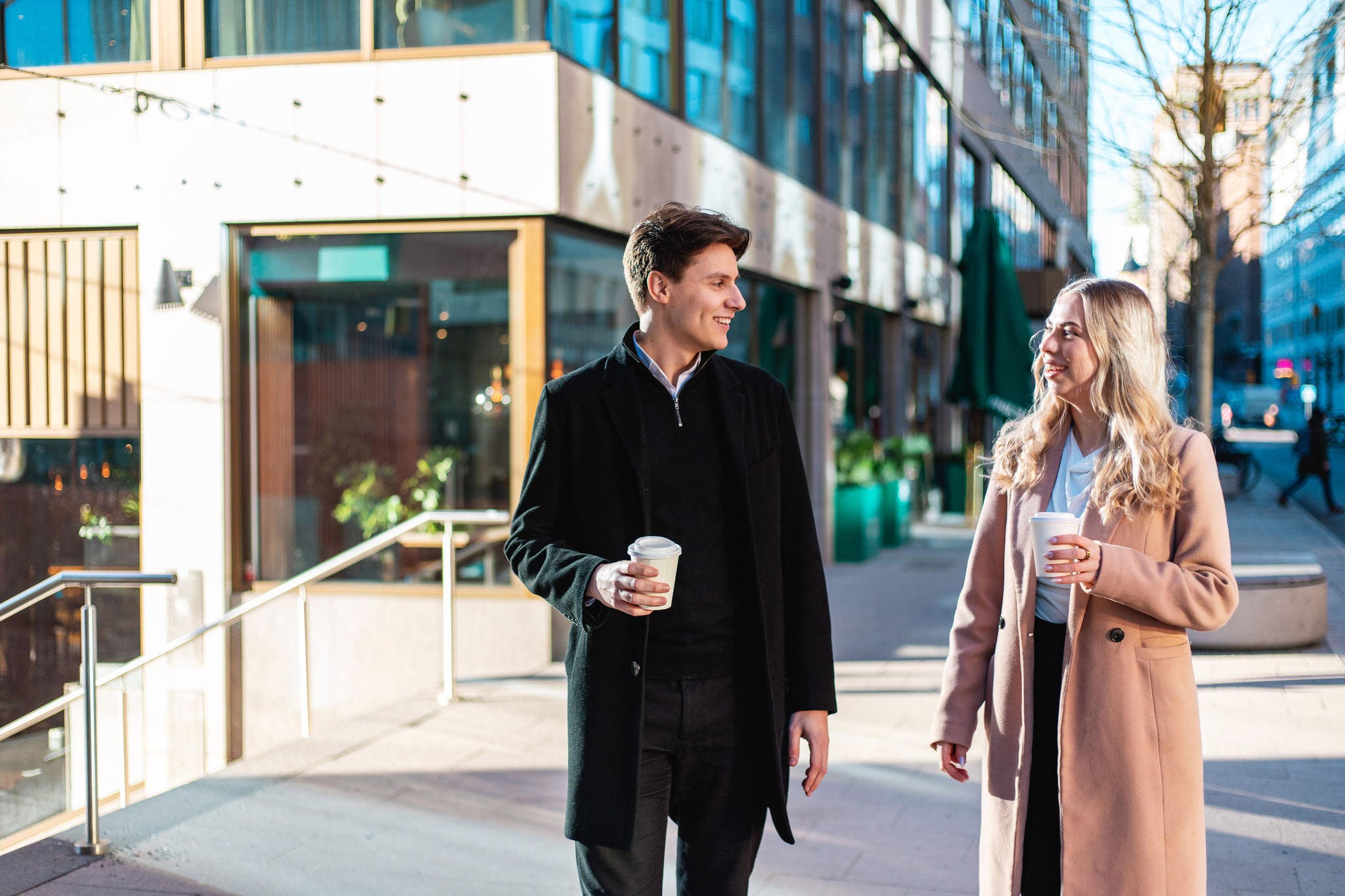 Två kollegor tar en kaffepaus utomhus