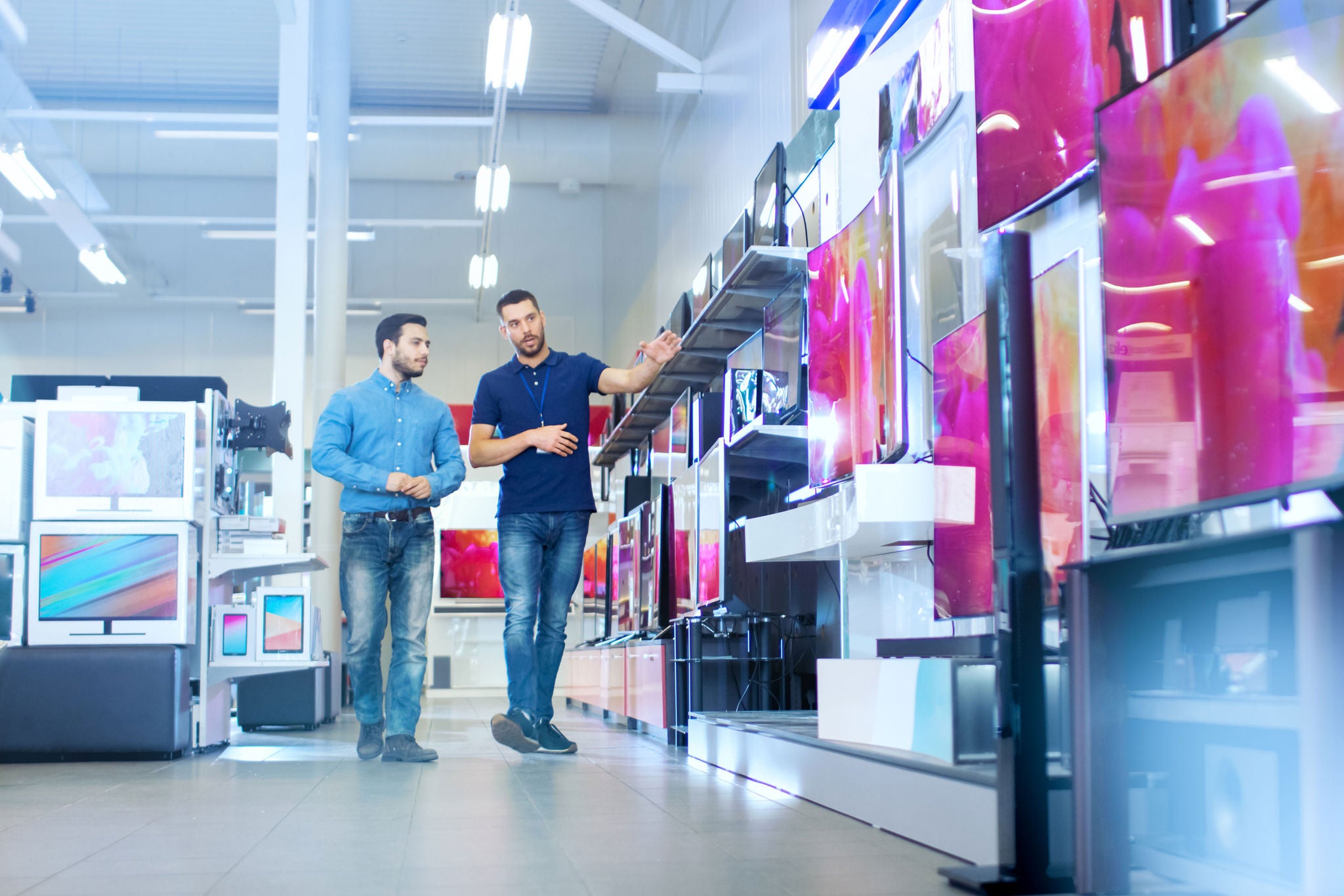 Two person walking in a electronic shop