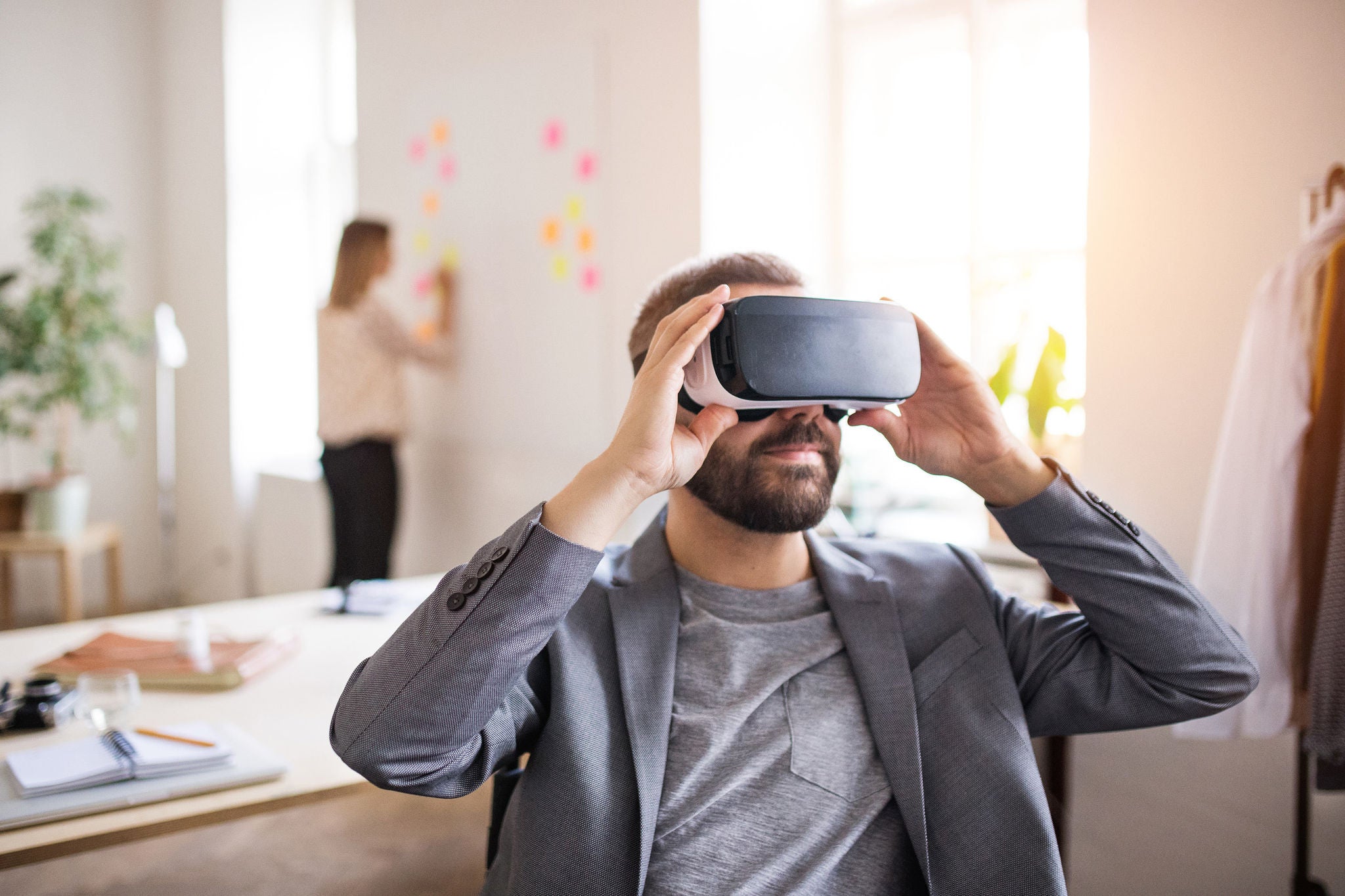 Zwei GeschÃ¤ftsleute mit Rollstuhl und VR-Brille im BÃ¼ro.