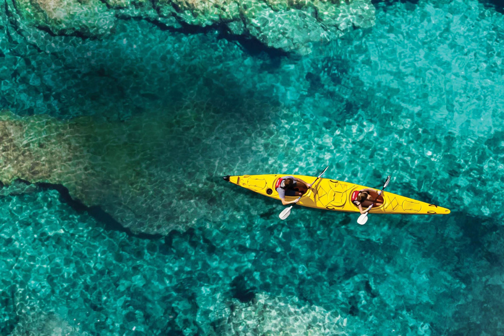 two people on a yellow kayak in the lake