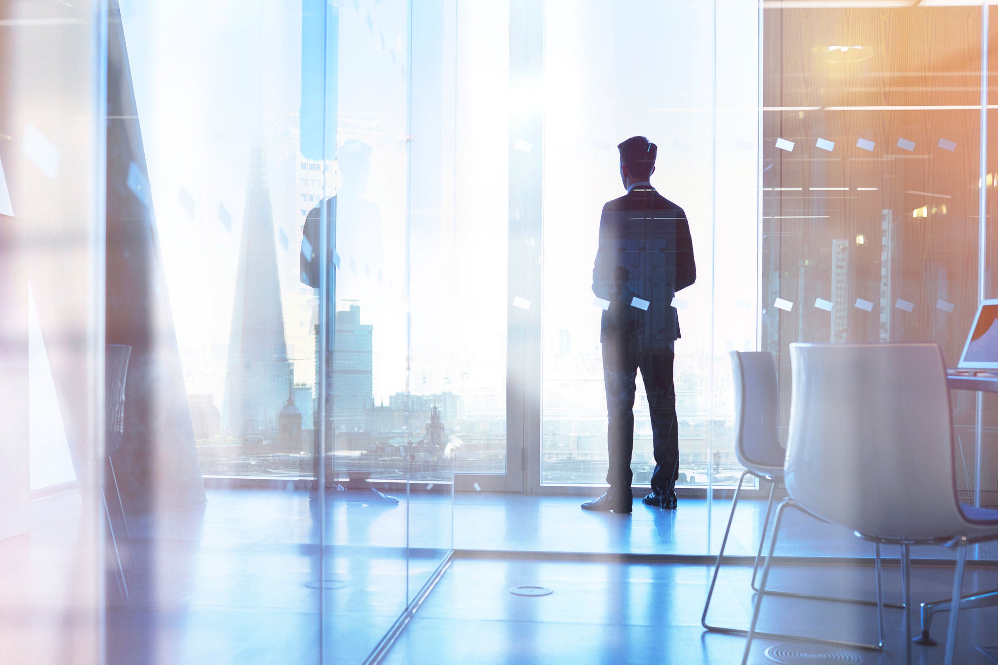 Businessman looking out of office over city