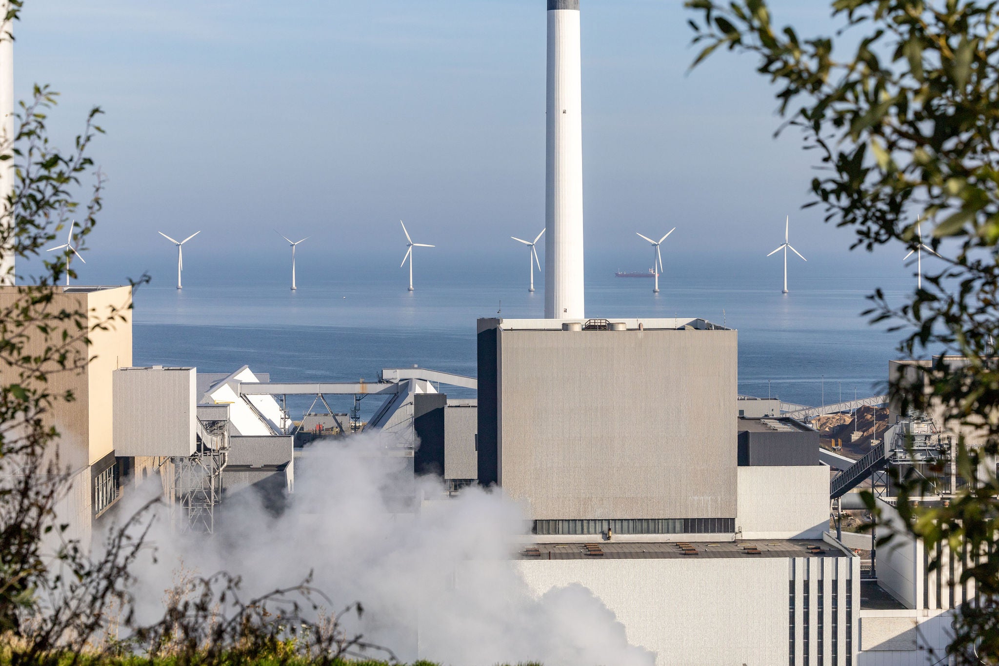 Copenhagen, Denmark A view over the CopenHaill power plant towards the Oresund and offshore wind turbines.