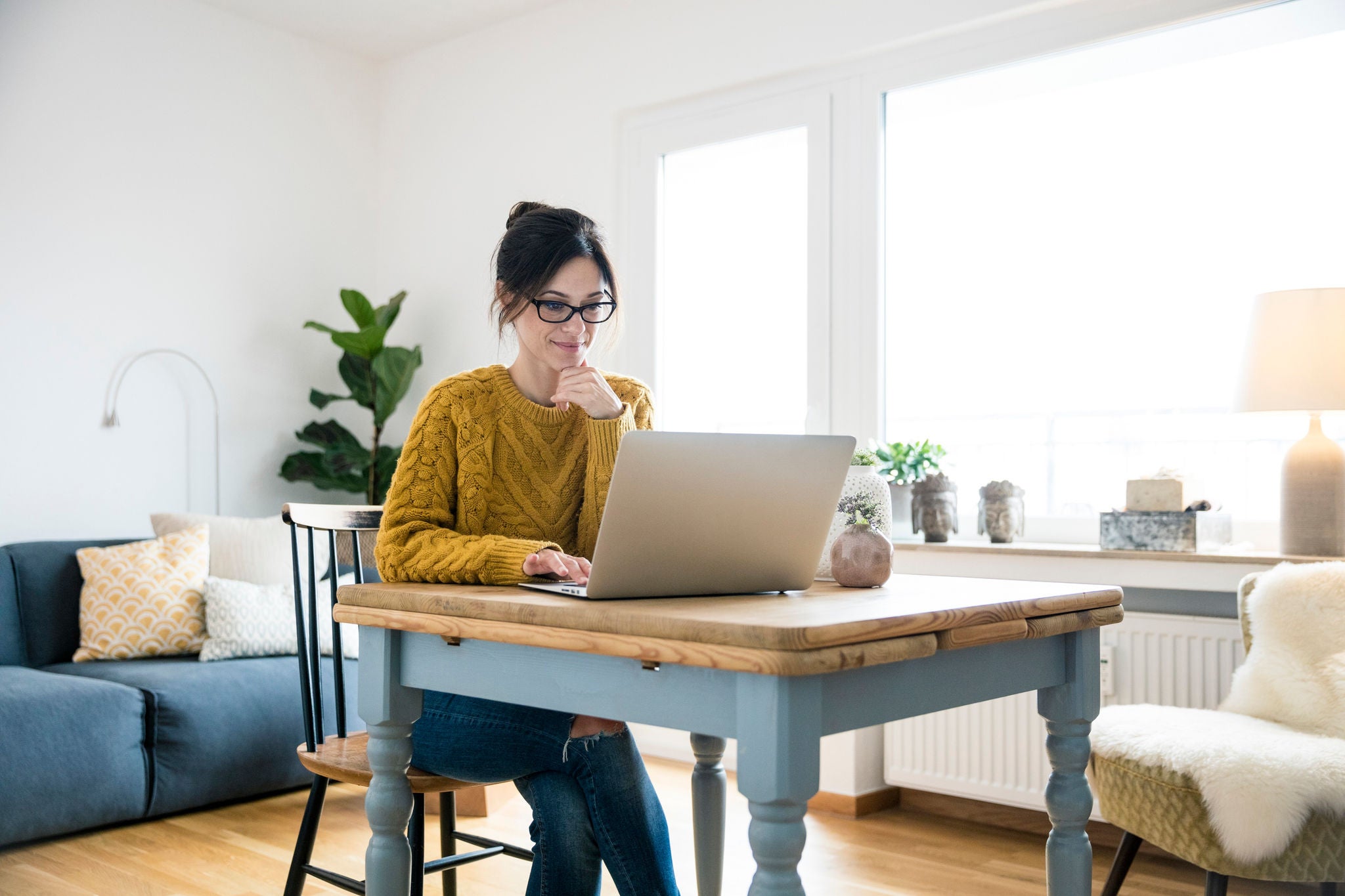 Woman sitting at table, using laptop