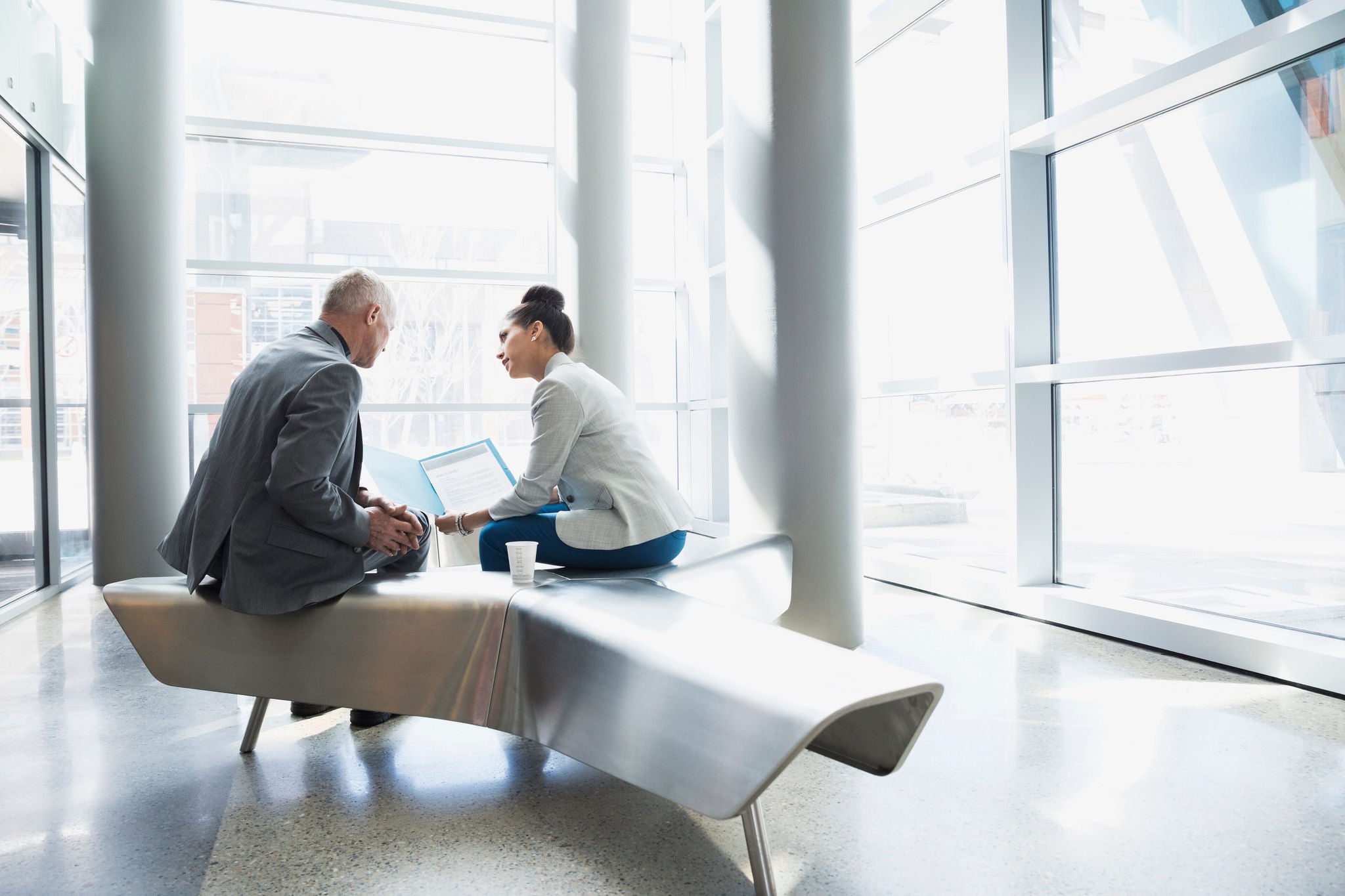 Business people reviewing paperwork in modern lobby