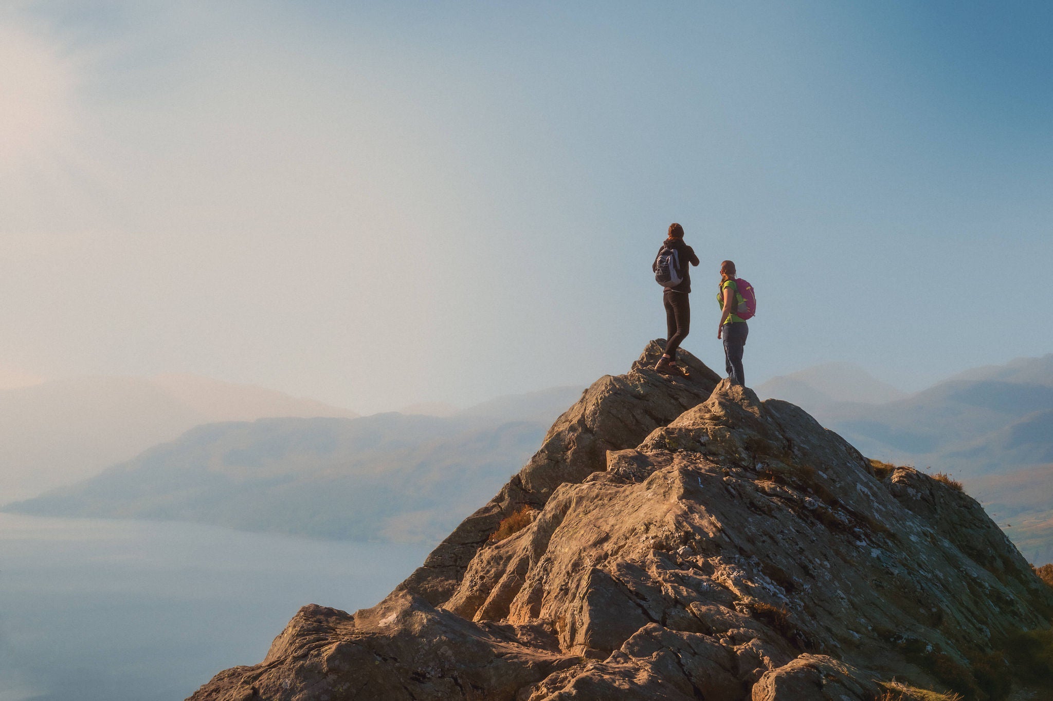 Young boy & girl standing on top of the mountain