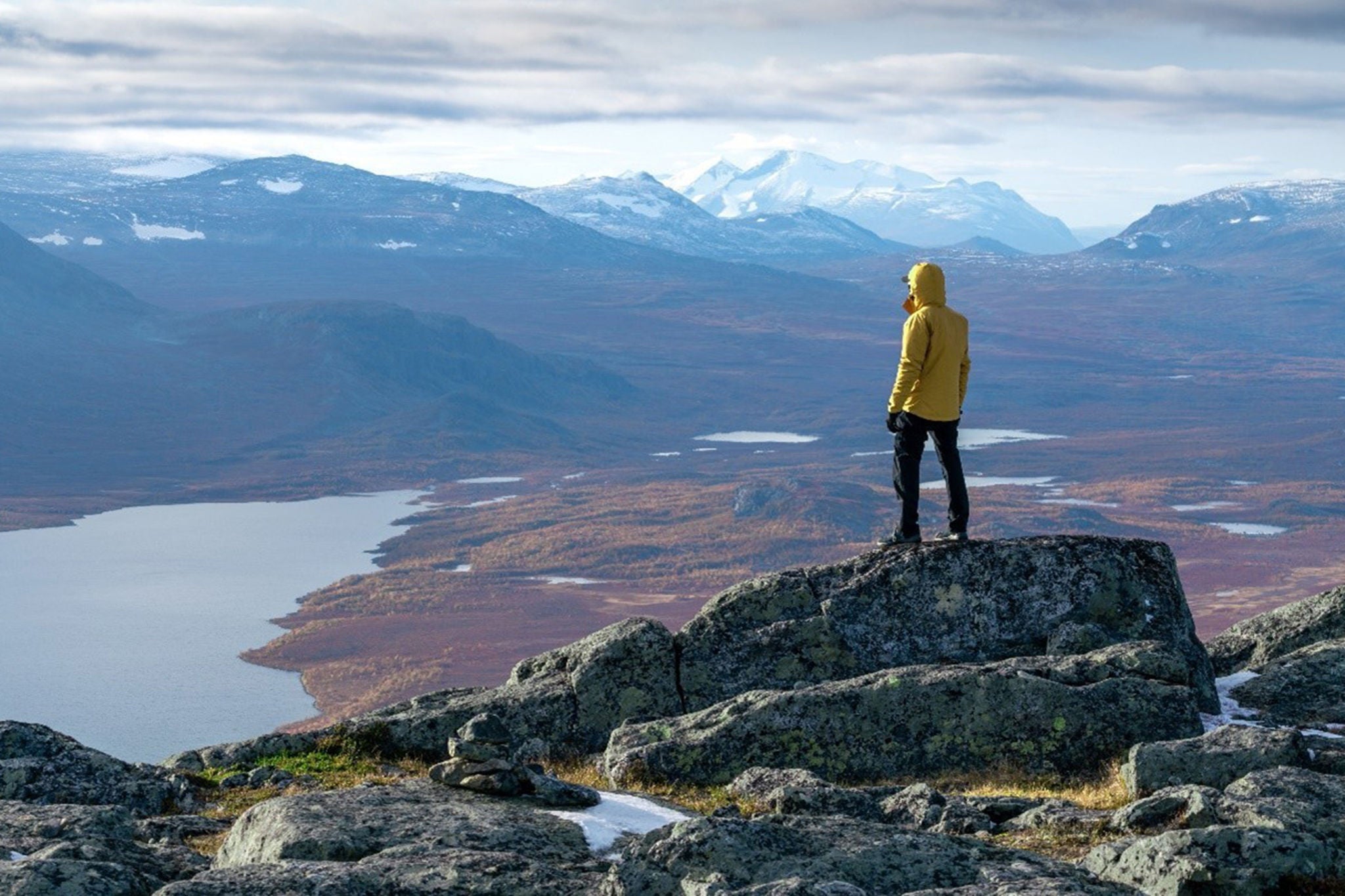 Bild pä Man som star högst upp på en bergstopp