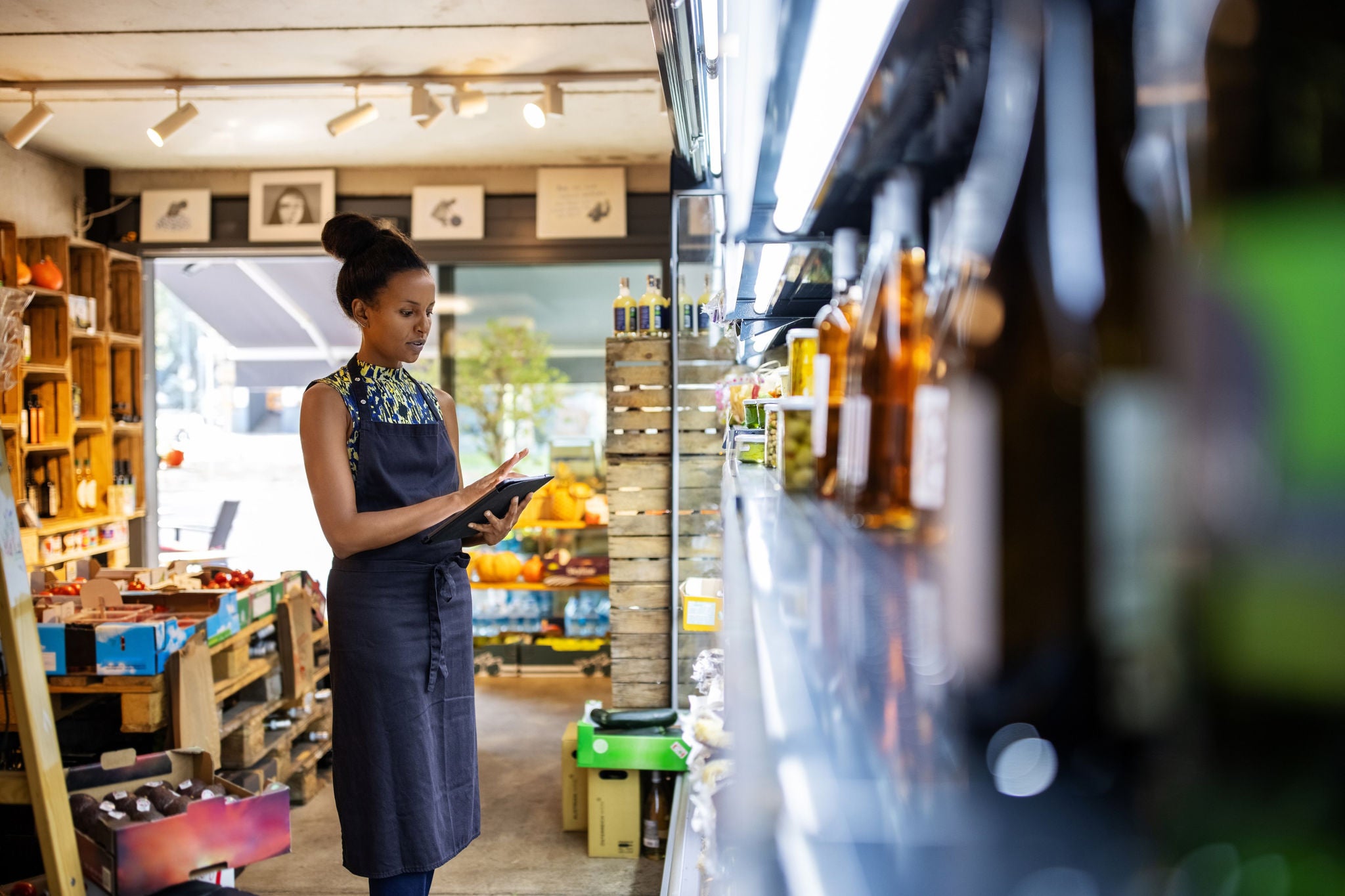 EY female owner checking inventory in supermarket