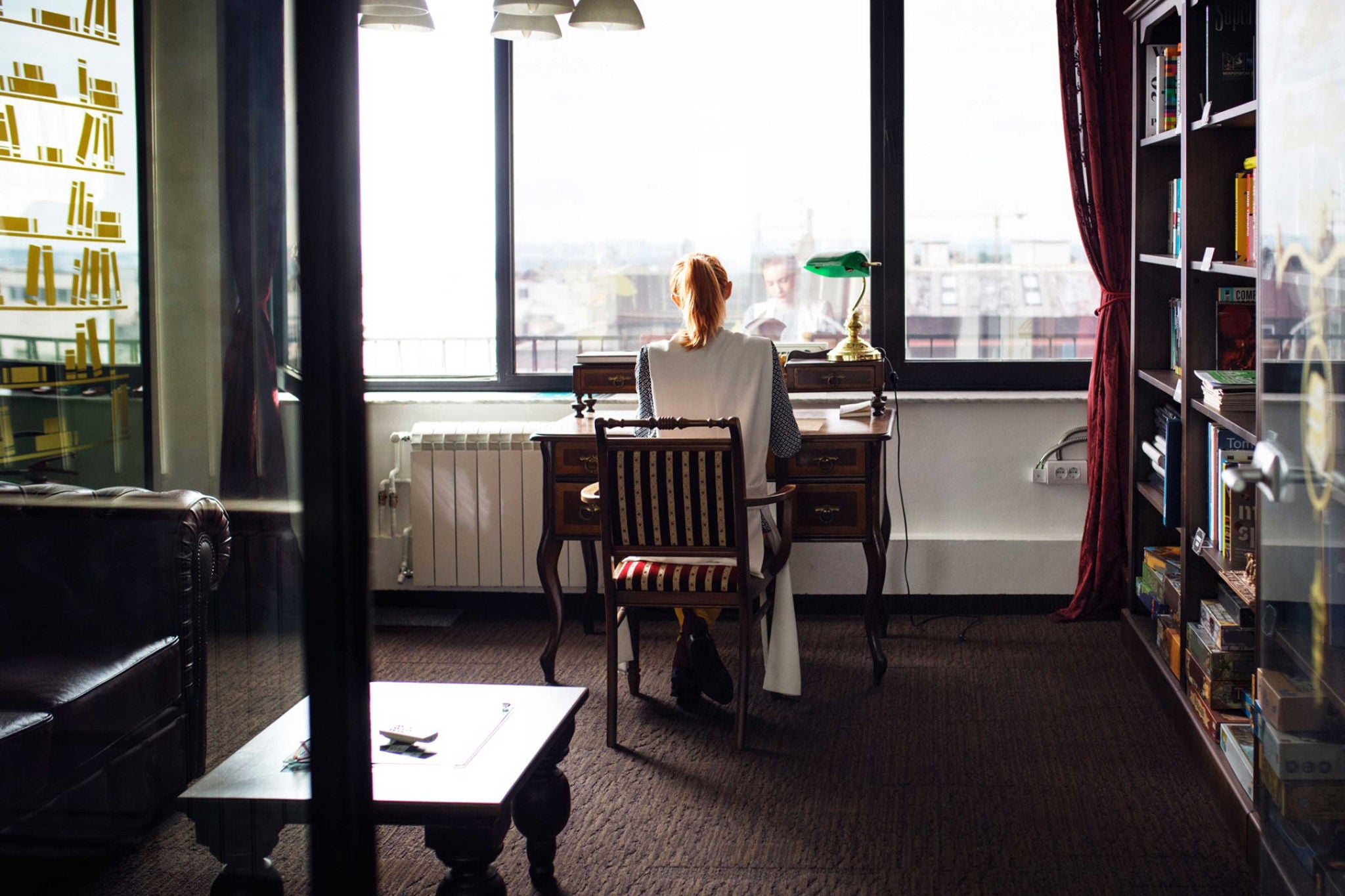 EY woman sits at a desk in her apartment