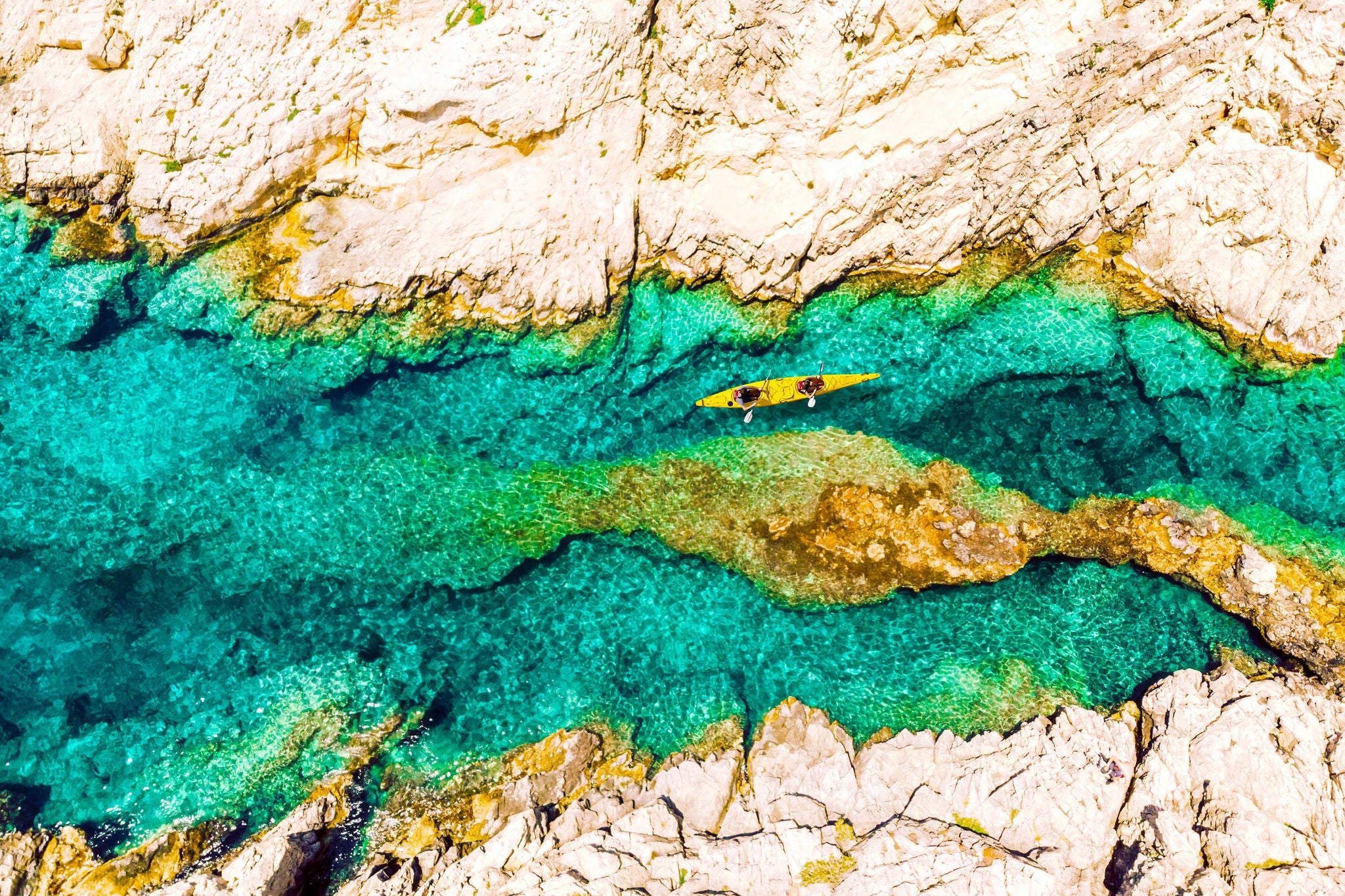 A direct view from above of a two-seater kayak in transparent waters 