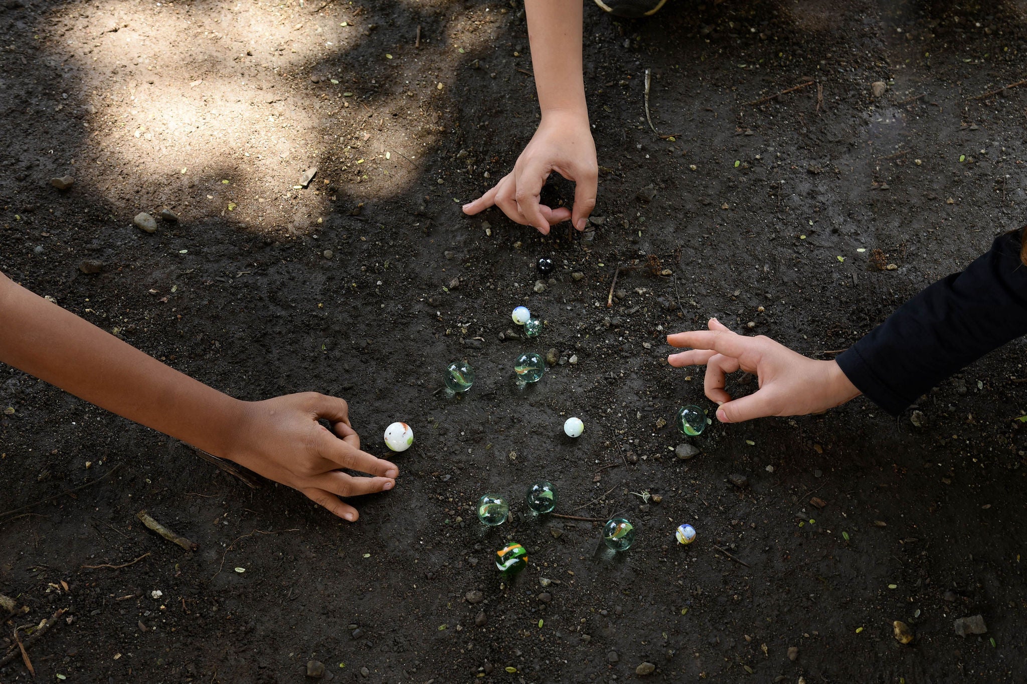 enfants jouant avec des billes dans la cour de la maison