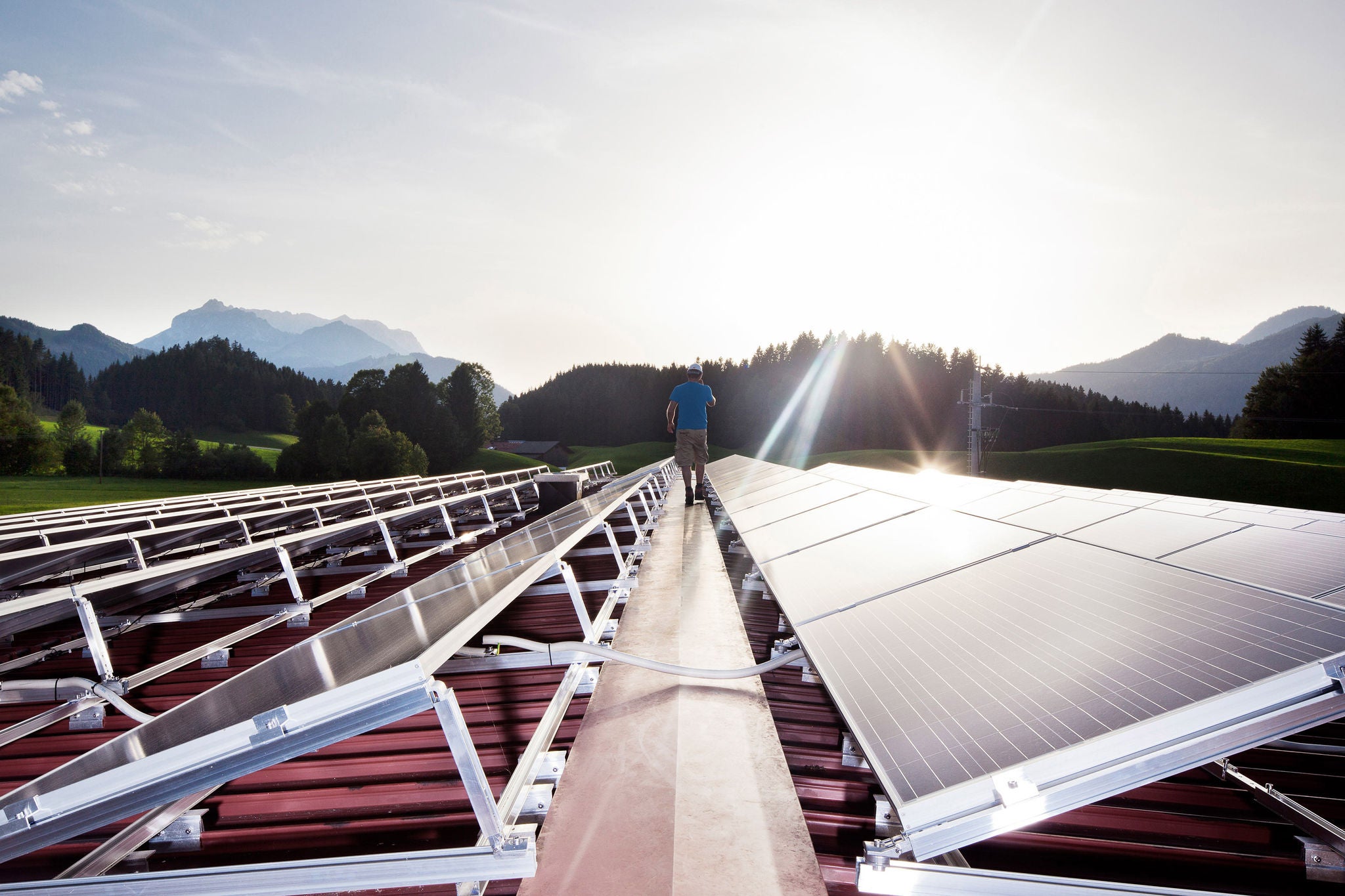 Arbeiter, der abends auf einer Solaranlage spazieren geht