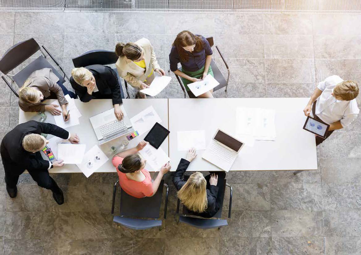 A man discussing with colleagues in a round table meeting.