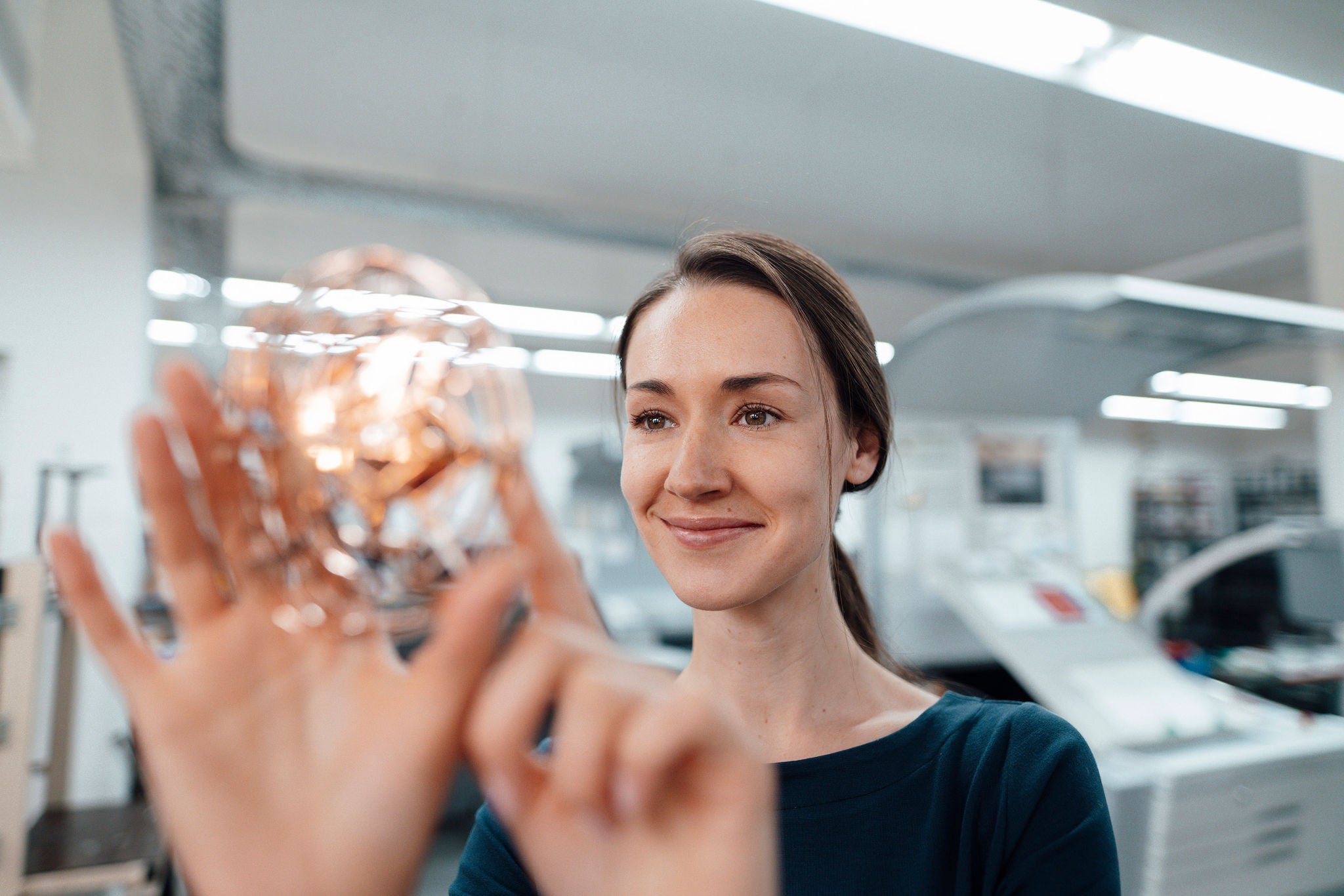 Female design professional touching 3D drone in workshop